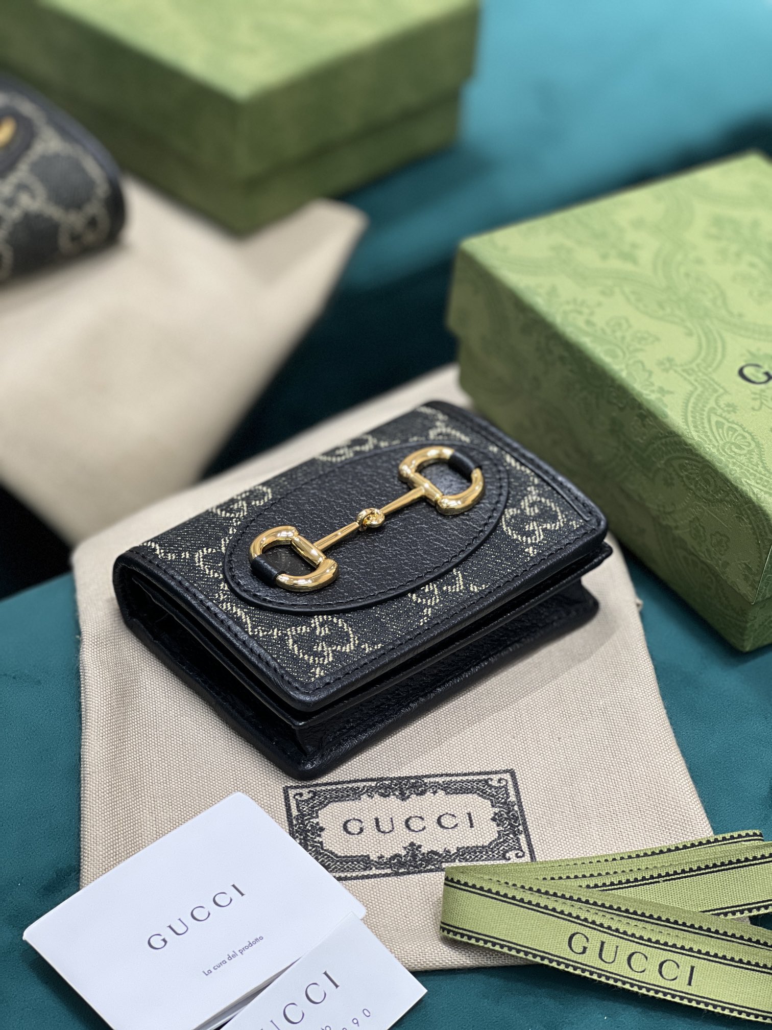 卡包 Gucci马衔扣1955系列不断发展壮大 Gucci 马衔扣1955系列小号卡包采用搭配黑色和象牙白色GG丹宁提花面料制作 621887