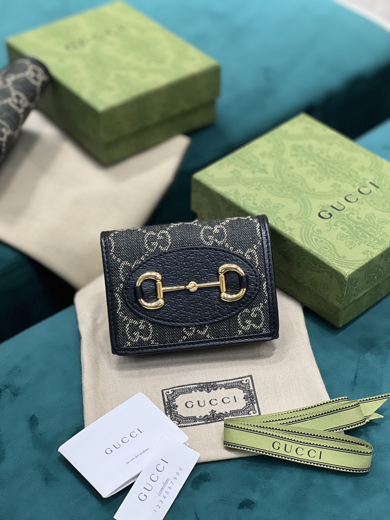 卡包 Gucci马衔扣1955系列不断发展壮大 Gucci 马衔扣1955系列小号卡包采用搭配黑色和象牙白色GG丹宁提花面料制作 621887