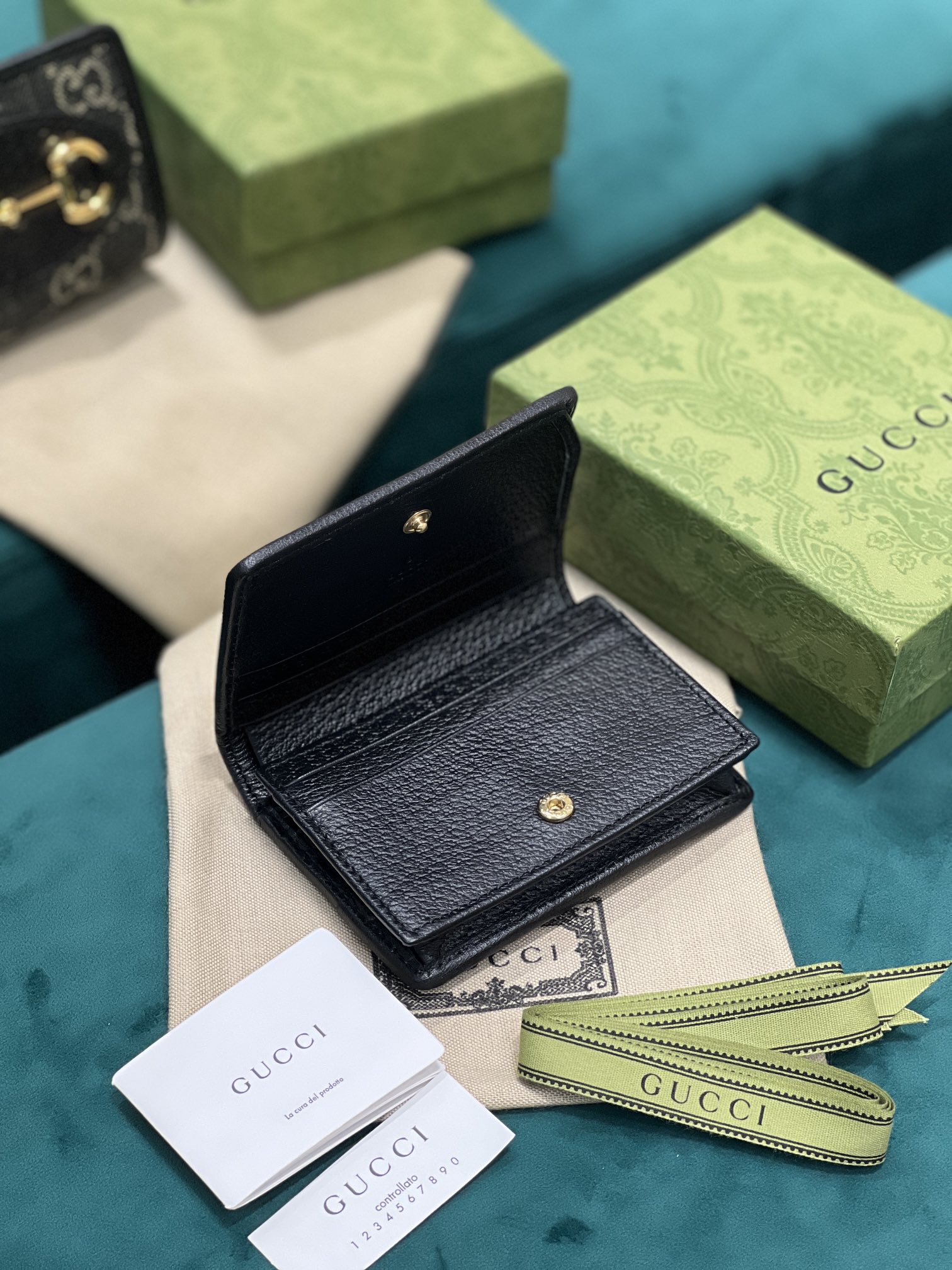 卡包 Gucci马衔扣1955系列不断发展壮大 Gucci 马衔扣1955系列小号卡包采用搭配黑色和象牙白色GG丹宁提花面料制作 621887