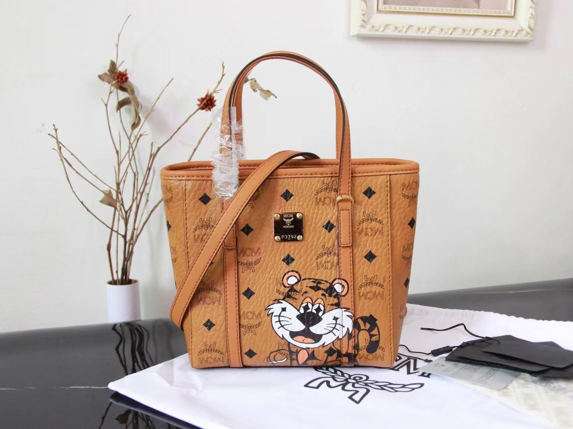 Top quality goods 💐【MCM Top Original】In 2022, MCM brand has created a playful zodiac image for the Year of the Tiger. The tiger's eyes are made up of the Bavarian diamond pattern, symbolizing its ambition and optimism. This Toni shopping bag features a unique and practical geometric design, with comfortable canvas compartments printed with a street-style chain link pattern, and designed with a top zipper closure. Size: 18.5 x 19.0 x 9.5 cm. image 1