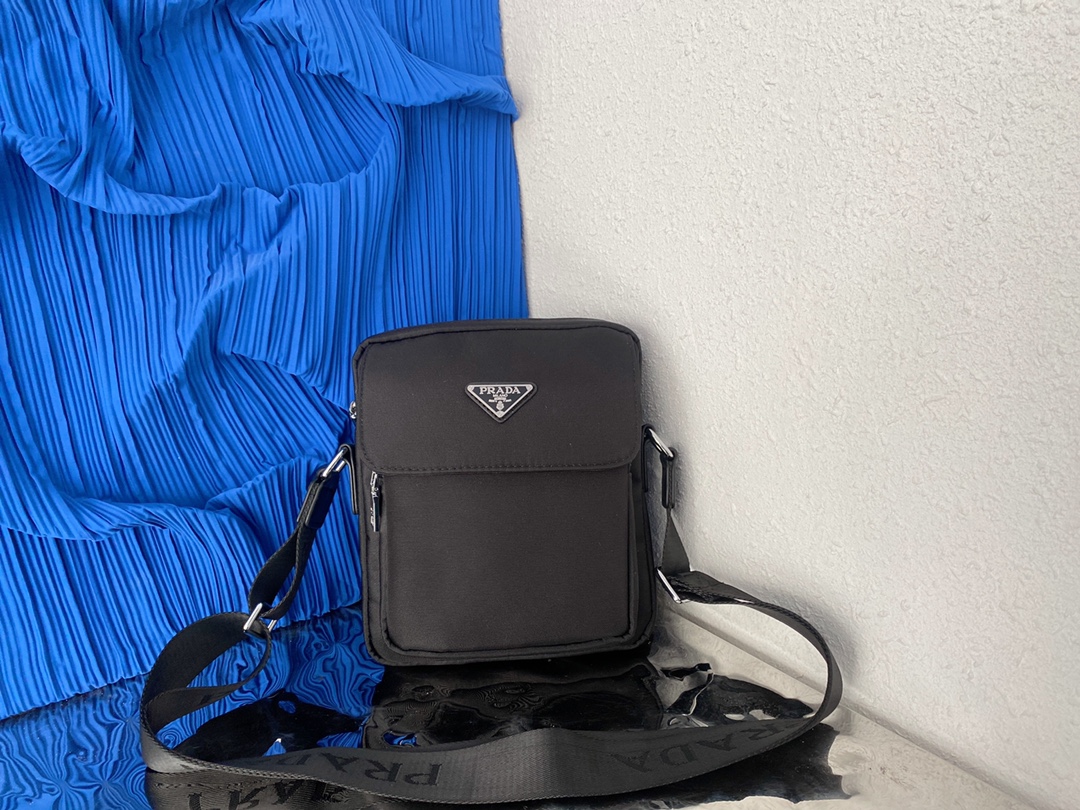 J0  普拉达 Prada  男士翻盖邮差包 帆布斜挎包 单肩包 采用精湛镶嵌细工，经典百搭 实物拍摄 原厂原版面料 高端品质 配送小票防尘袋 22 x 19 cm。
