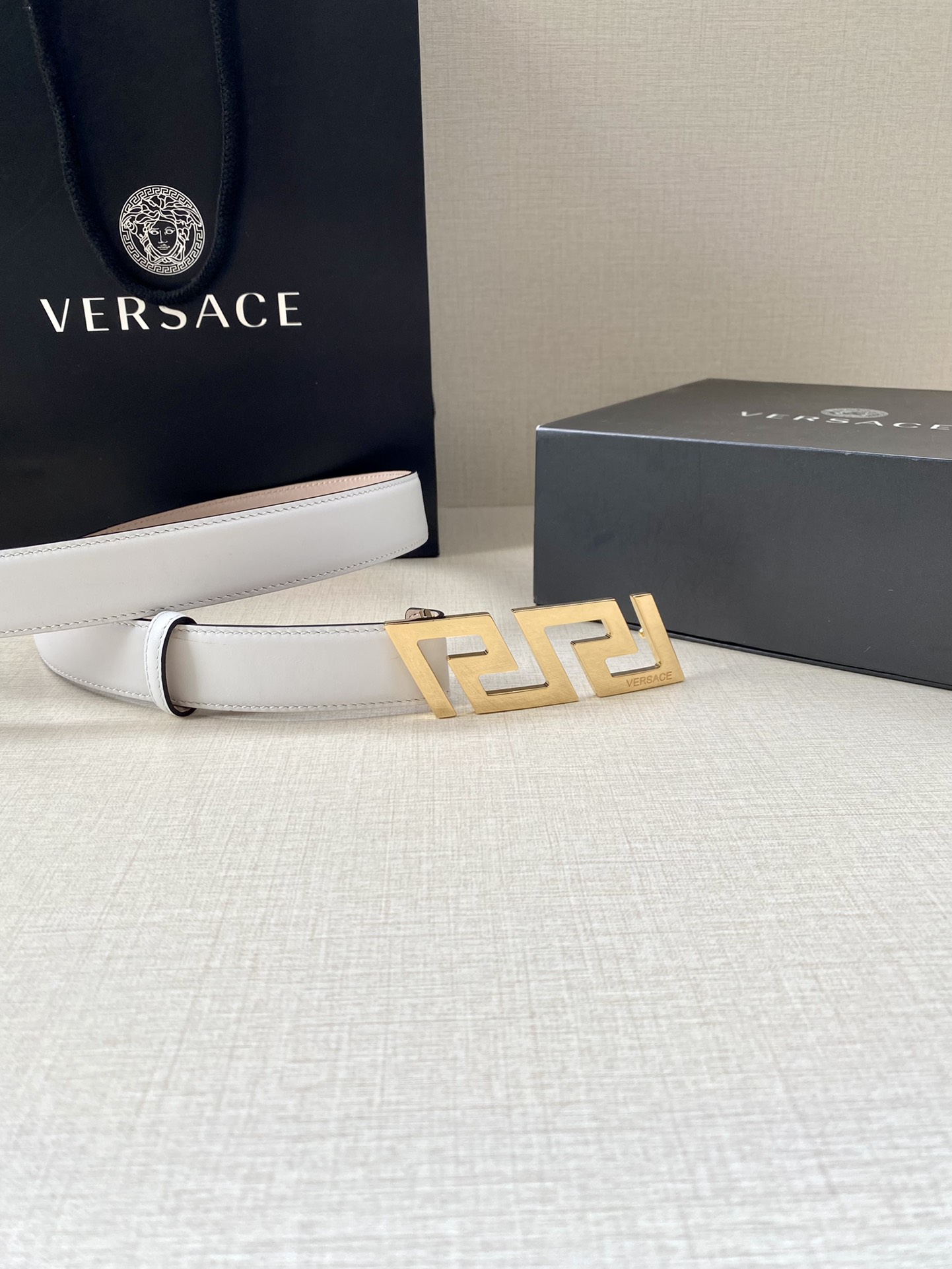  VERSACE 宽度3.0cm 此款腰带由优质皮革制成，饰有La Greca彰显个性设计。该铆钉腰带饰