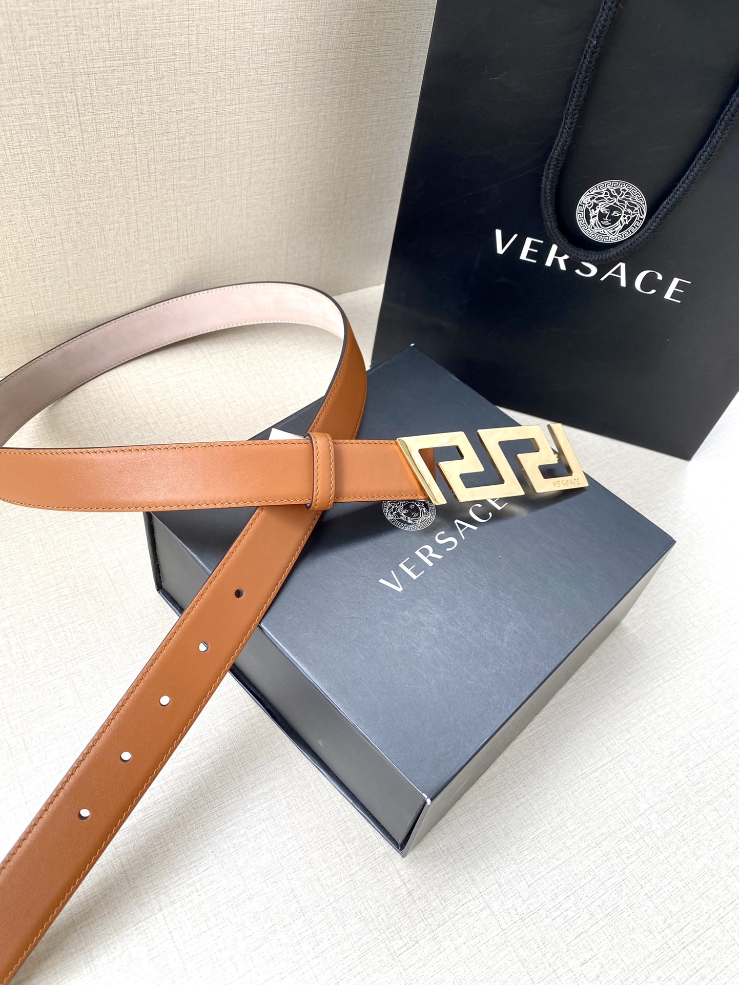  VERSACE 宽度3.0cm 此款腰带由优质皮革制成，饰有La Greca彰显个性设计。该铆钉腰带饰