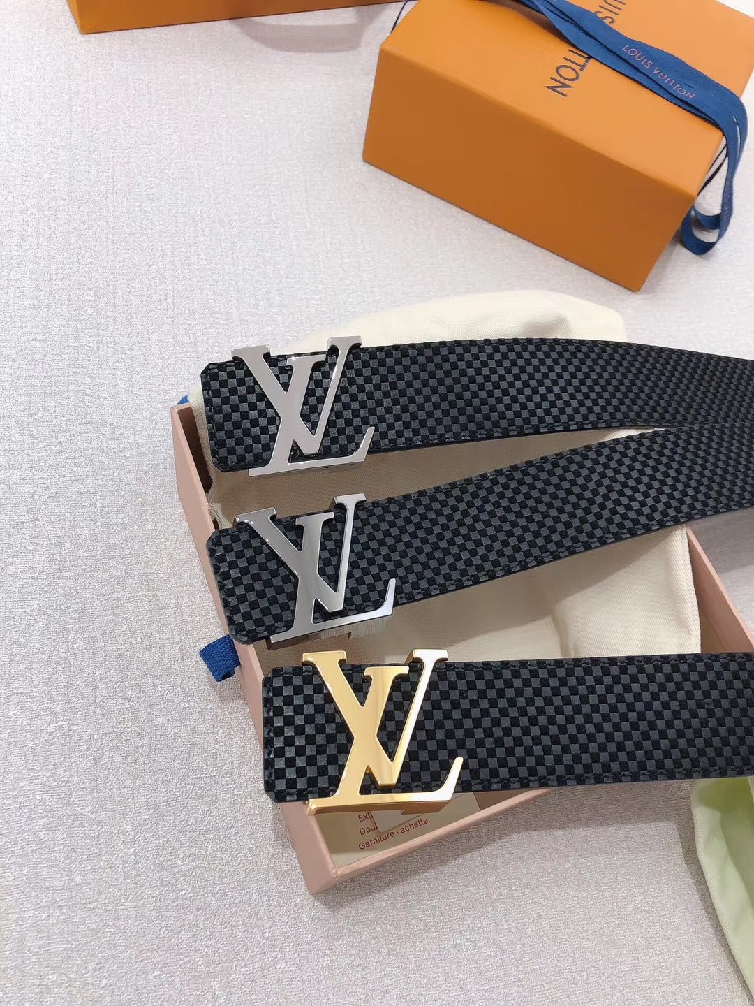 I0 在 LV Initiales 腰带的中央位置,赫然是标志性的首字母标识. 绒面小牛皮上精美的迷你 Damier 压纹图案彰显了路易威登品牌的精湛制作工艺.