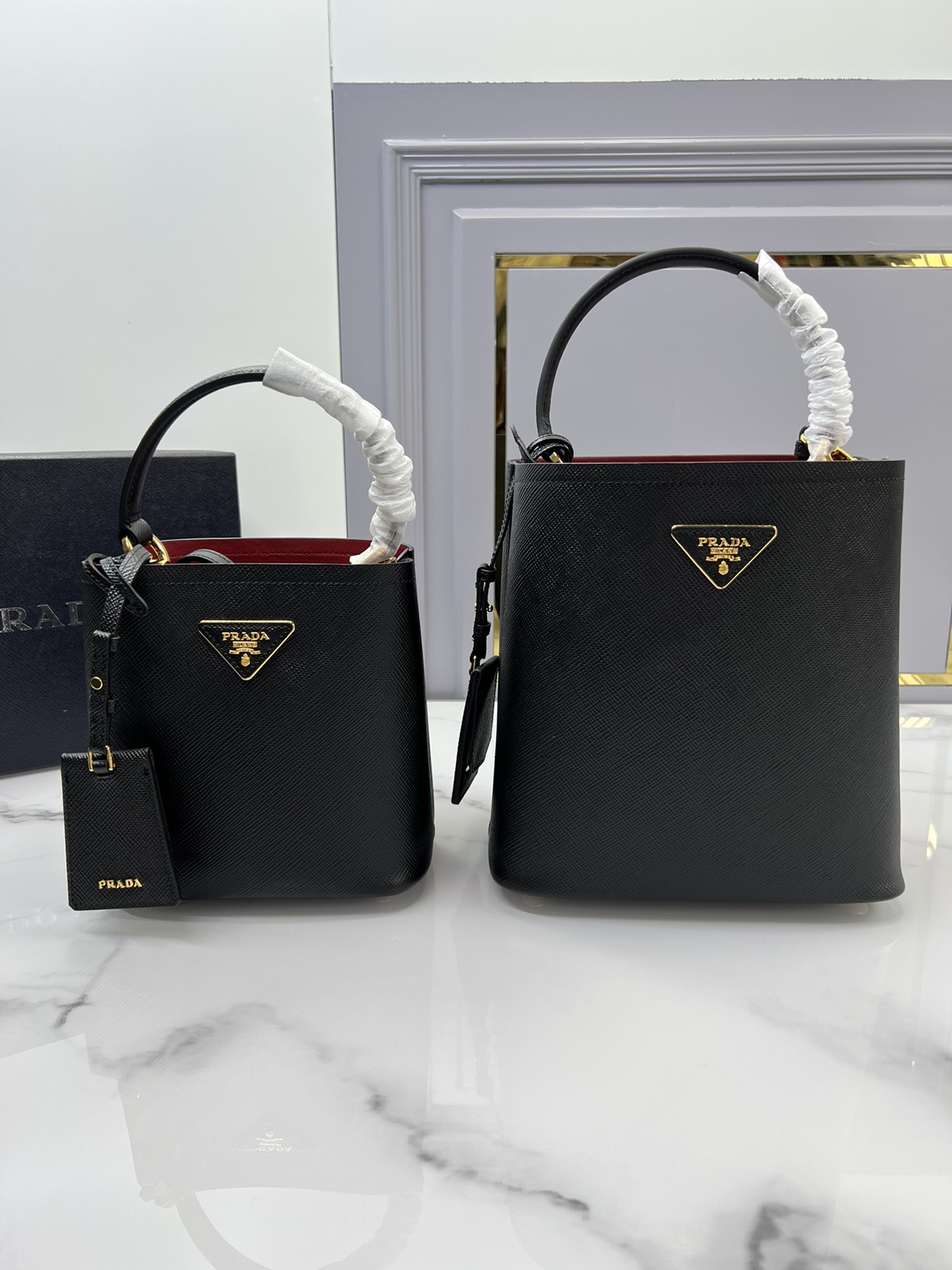Comparison of large and small bucket bags Prada