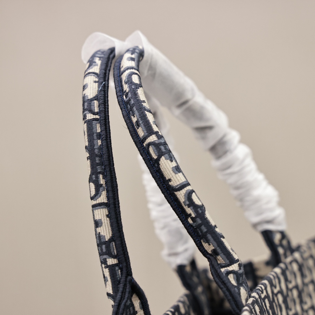 DIOR刺绣托特购物袋💰360【顶级原单】 中号：36.5*28*17cm 大号：41.5*35*18cm 这款 Book Tote 手袋灵感来自女装创意总监玛丽亚·嘉茜娅·蔻丽 (Maria Grazia Chiuri)，是体现 Dior 审美的主打产品，通体饰以蓝色 Oblique 印花，正面饰以醒目的“Christian Dior”标志，是携带各种日常用品的理想之选，优雅的设计彰显 Dior 的精湛工艺。