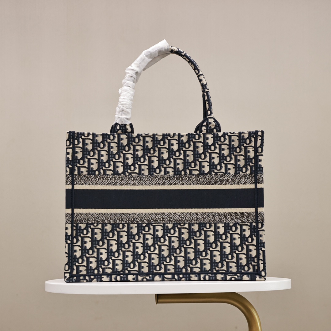 DIOR刺绣托特购物袋💰360【顶级原单】 中号：36.5*28*17cm 大号：41.5*35*18cm 这款 Book Tote 手袋灵感来自女装创意总监玛丽亚·嘉茜娅·蔻丽 (Maria Grazia Chiuri)，是体现 Dior 审美的主打产品，通体饰以蓝色 Oblique 印花，正面饰以醒目的“Christian Dior”标志，是携带各种日常用品的理想之选，优雅的设计彰显 Dior 的精湛工艺。