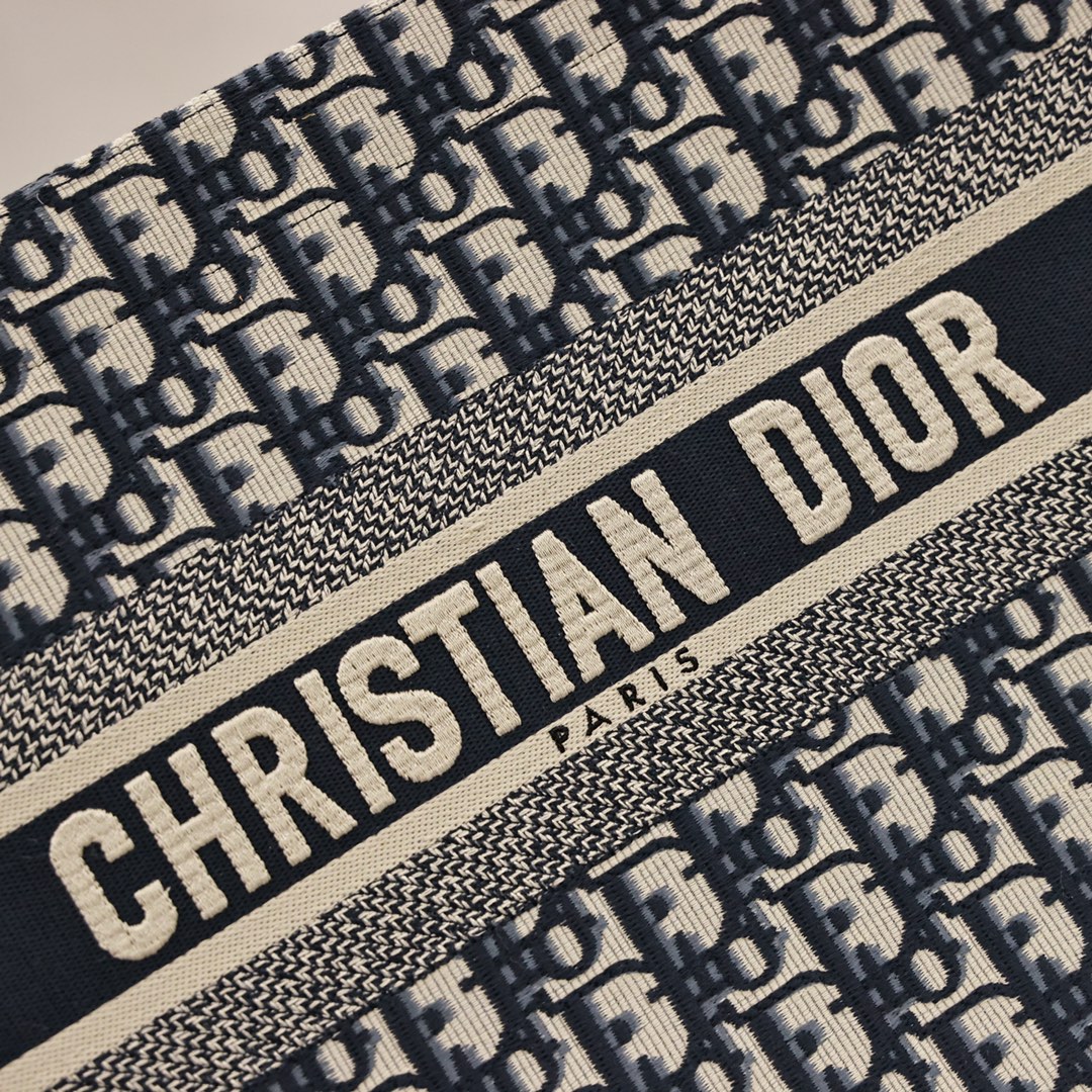 DIOR刺绣托特购物袋💰360【顶级原单】 中号：36.5*28*17cm 大号：41.5*35*18cm 这款 Book Tote 手袋灵感来自女装创意总监玛丽亚·嘉茜娅·蔻丽 (Maria Grazia Chiuri)，是体现 Dior 审美的主打产品，通体饰以蓝色 Oblique 印花，正面饰以醒目的“Christian Dior”标志，是携带各种日常用品的理想之选，优雅的设计彰显 Dior 的精湛工艺。