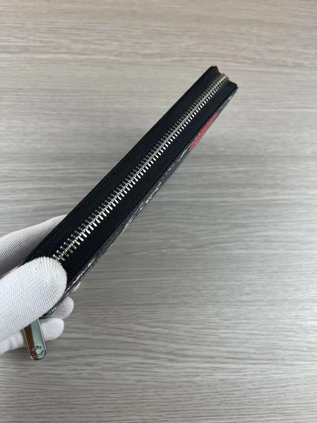 Close-up of the zipper pocket in the long leather wallet.