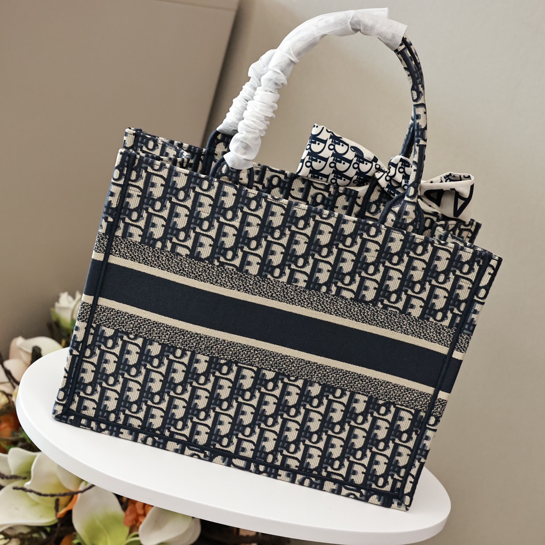 DIOR刺绣托特购物袋💰360【高端原单】 中号：36.5*28*17cm 大号：41.5*35*18cm 这款 Book Tote 手袋灵感来自女装创意总监玛丽亚·嘉茜娅·蔻丽 (Maria Grazia Chiuri)，是体现 Dior 审美的主打产品，通体饰以蓝色 Oblique 印花，正面饰以醒目的“Christian Dior”标志，是携带各种日常用品的理想之选，优雅的设计彰显 Dior 的精湛工艺。