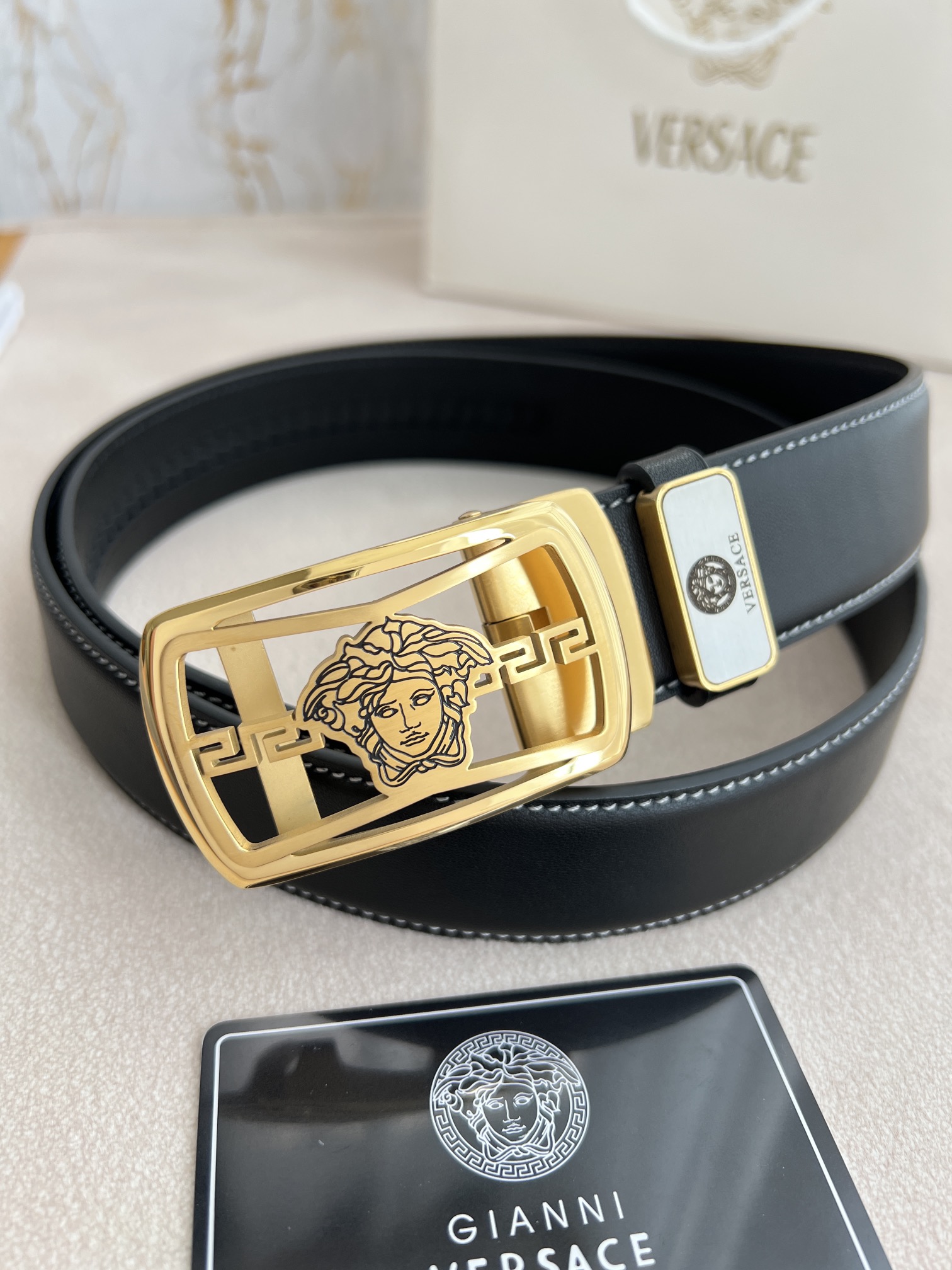 I5  Versace 范思哲 VERSACE.皮带腰带自动皮带p 型号：自动带身,纯钢材质经典人头自动扣,图片实物拍摄 腰带：百分百头层牛皮,自动带身,保证真皮.24k纯钢扣永不掉色专柜同等质量,经典头层牛皮平纹白线头层牛皮平纹底,金扣,镂空人头纯钢材质扣头,可自由裁剪,送人自用首选 包装请认准如图专柜包装,赠送拆卸工具,原版电子票,宽度3.5cm