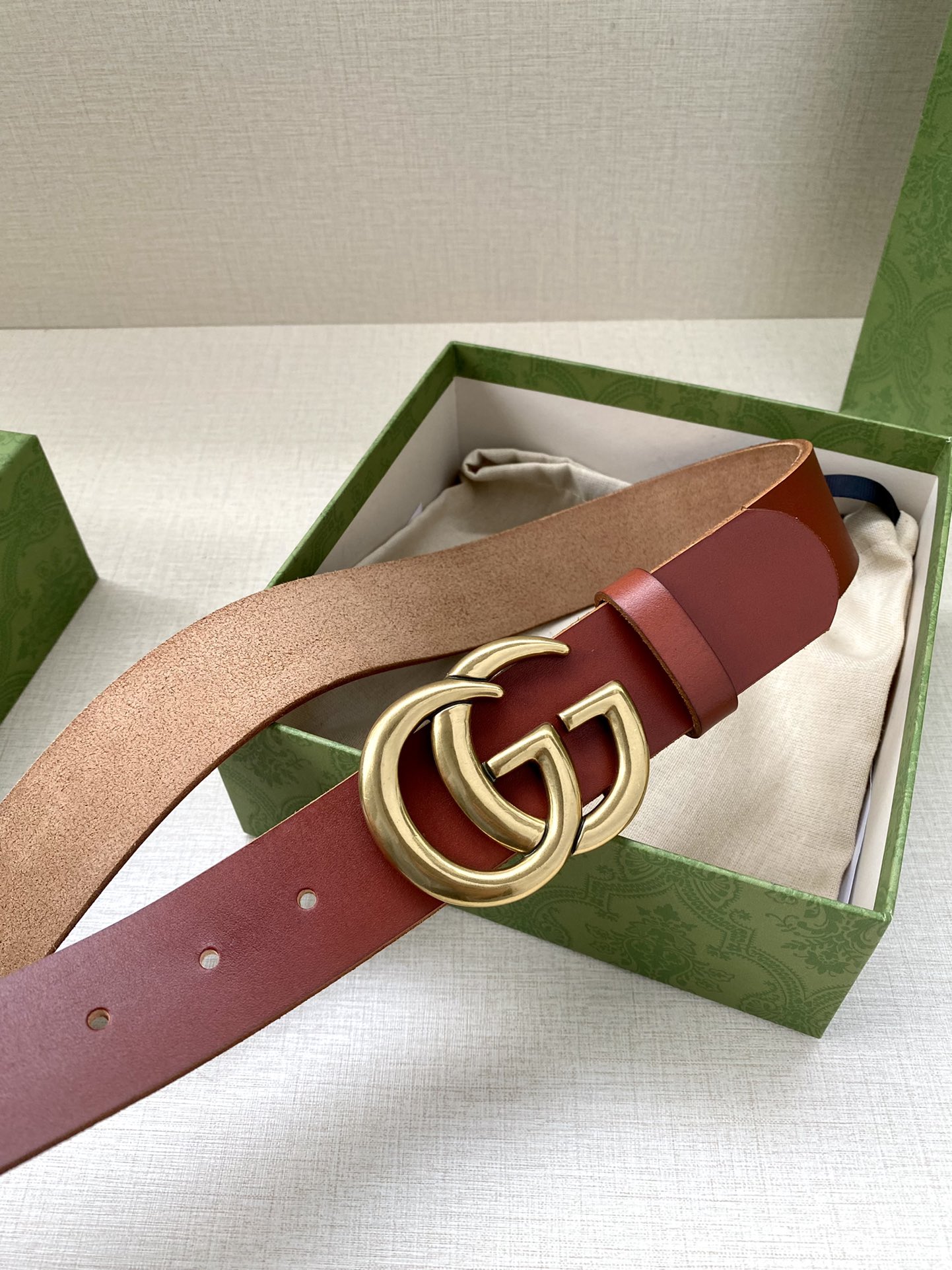 GUCCI单层树膏皮革腰带，配有品牌标志性双G带扣。无涂层褪色皮革材质。棕色皮革钯金色调配件双G带扣搭扣