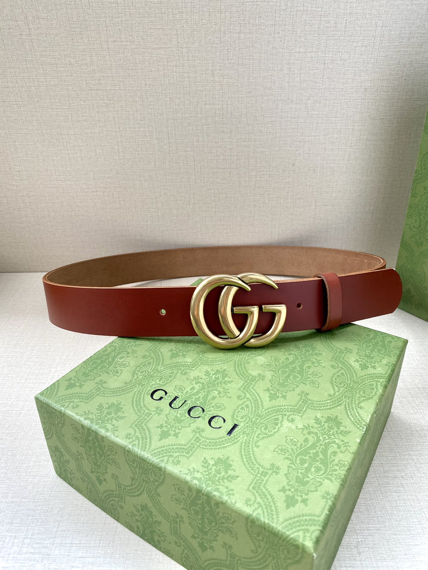 GUCCI单层树膏皮革腰带，配有品牌标志性双G带扣。无涂层褪色皮革材质。棕色皮革钯金色调配件双G带扣搭扣