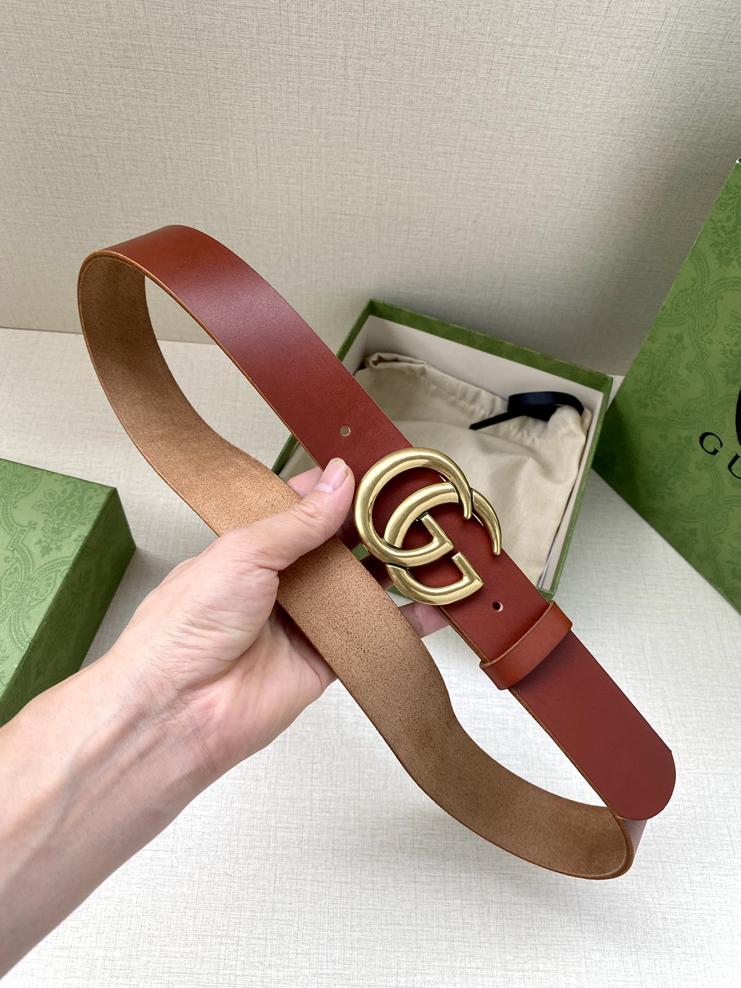 GUCCI单层树膏皮革腰带，配有品牌标志性双G带扣。无涂层褪色皮革材质。棕色皮革钯金色调配件双G带扣搭扣
