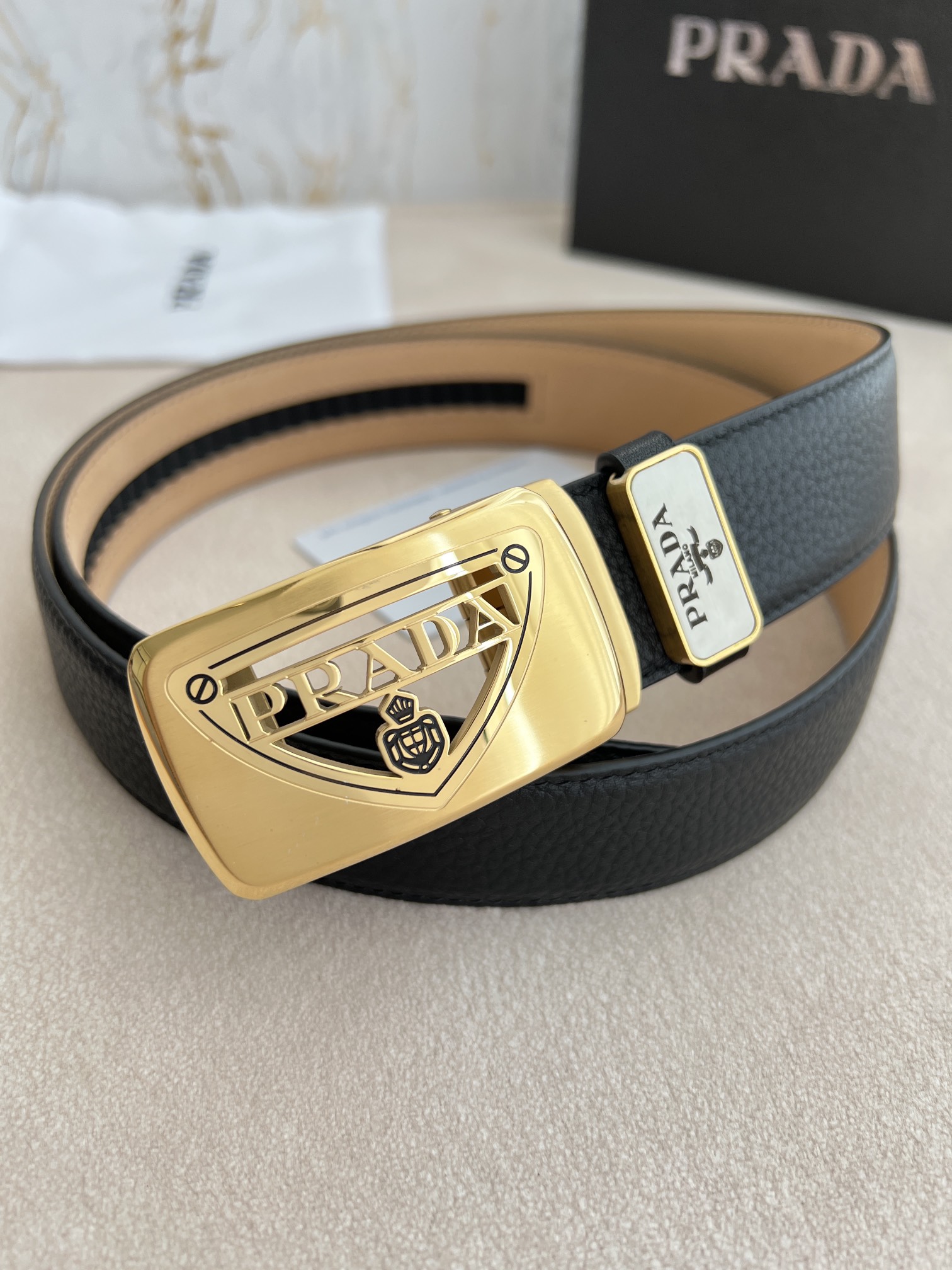 I5  Prada 普拉达  腰带·皮带自动带 型号：自动带,经典镂空纯钢材质自动扣,图片实物拍摄 材料：百分百头层牛皮,保证真皮.24k纯钢扣专柜同等质量, 双面头层牛皮荔枝纹头层树膏磨砂皮底,金扣,镂空纯钢材质自动扣,可自由裁剪,送人自用首选 包装请认准如图专柜包装,赠送装配工具,原版电子发票,宽度3.5cm