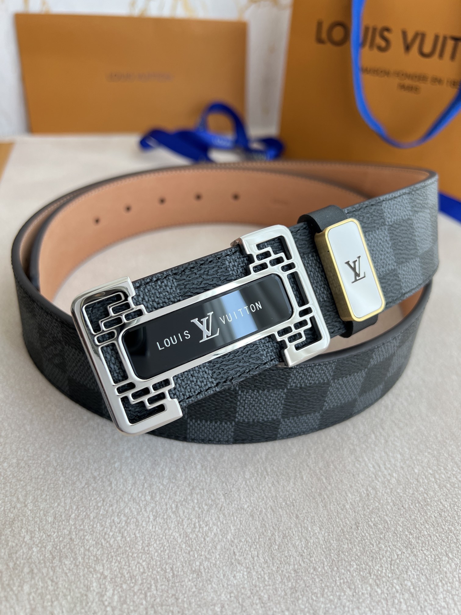 I0 Louis vuitton 路易威登 LV 腰带皮带原单 型号：挂扣,经典纯钢材质亚克力花纹挂扣,图片实物拍摄 材料：头层牛皮,挂扣系列,纯钢材质扣头,钯镀电镀工艺永不掉色.原版经典黑格头层树膏磨砂皮底,银扣,专柜同等质量,送人自用首选 包装如图专柜包装,赠送打孔器,原版电子票,宽度3.8cm