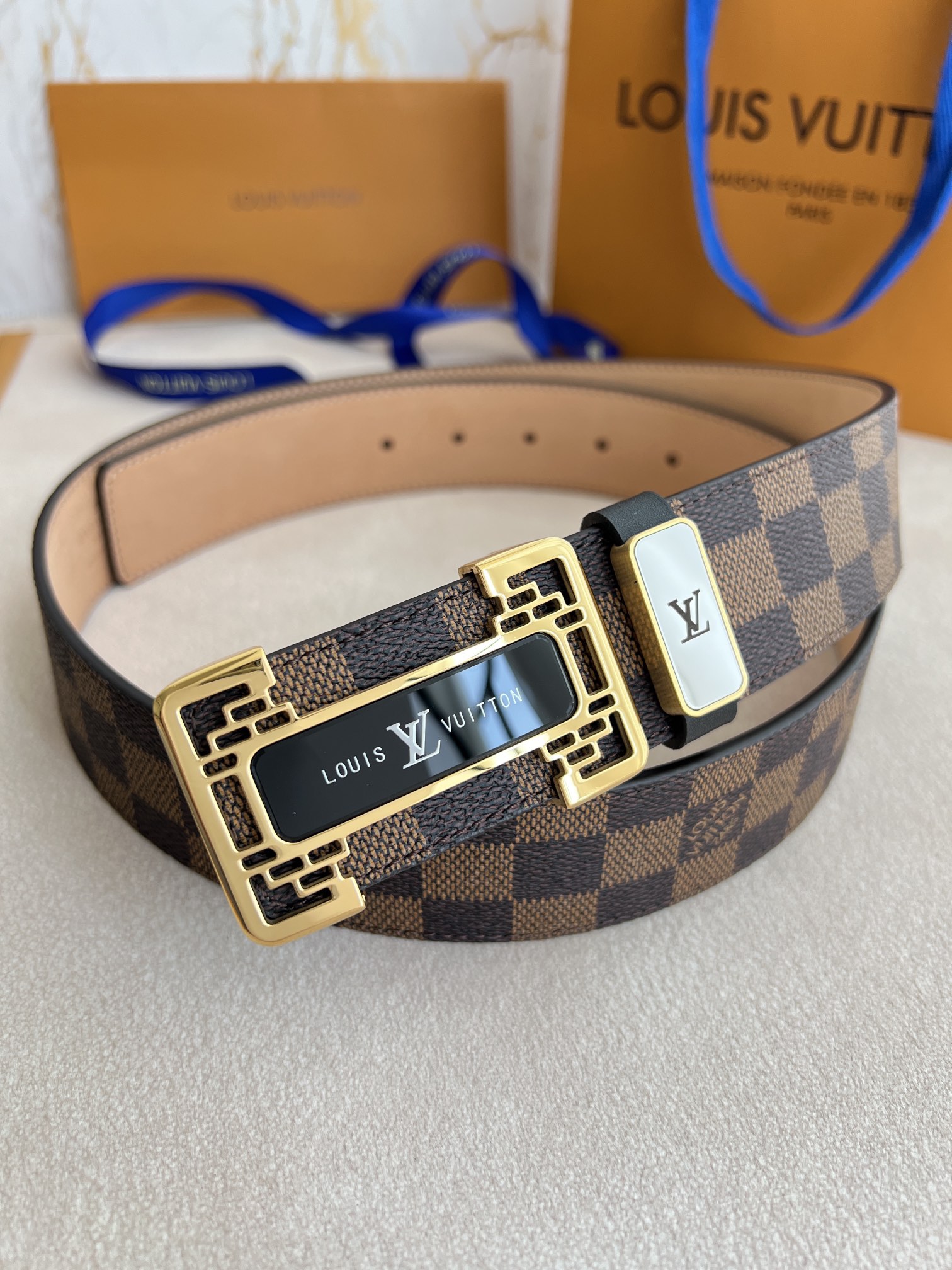 I0 Louis vuitton 路易威登 LV 腰带皮带原单 型号：挂扣,经典纯钢材质亚克力花纹挂扣,图片实物拍摄 材料：头层牛皮,挂扣系列,纯钢材质扣头,钯镀电镀工艺永不掉色.原版经典咖,黑格头层树膏磨砂皮底,专柜同等质量,送人自用首选 包装如图专柜包装,赠送打孔器,原版电子票,宽度3.8cm