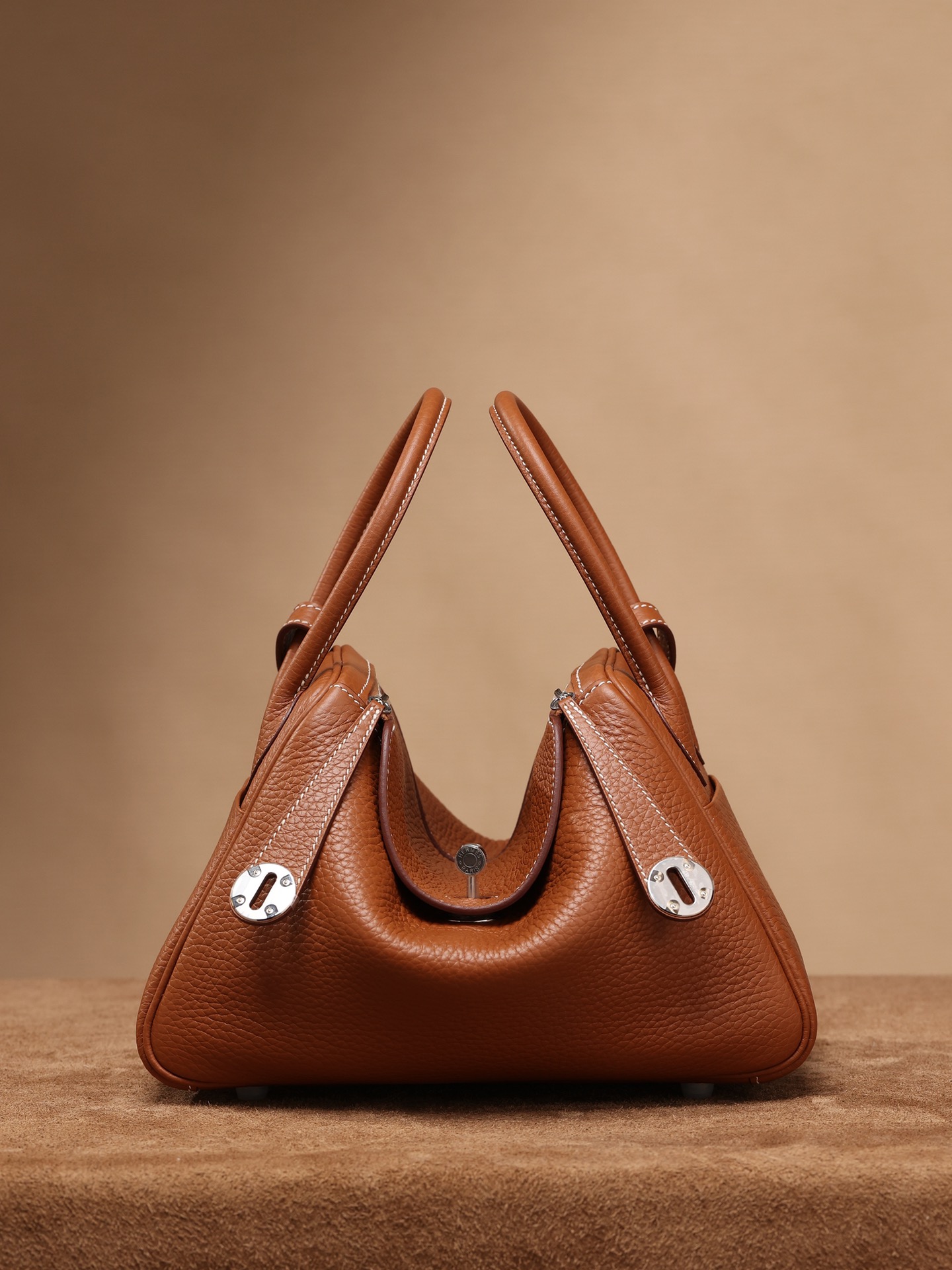 Channel goods reach 95% authenticity of genuine products, exclusive source.  
Lindy 26cm, golden brown with silver buckle.  
Exclusive channel goods, original European factory leather and hardware assembly, ZP leftover stock.  
Size: 26*18*14 cm.  

Lindy uses genuine factory TC leather. What is TC leather? It’s Hermes’ Clemence leather, called TC leather, one of Hermes’ most popular leathers. It has fewer colors than Togo but a finer grain, higher oil content, softer texture, and a slight natural drape.  

Appreciate the beauty of exclusive sources.  
Blind buy recommended.  

Channel goods contact: 9958088780  
Pure handmade: 9943088530  
Semi-handmade wax thread: 9918588245  
Machine-stitched top-grain cowhide: 998588135 image 1