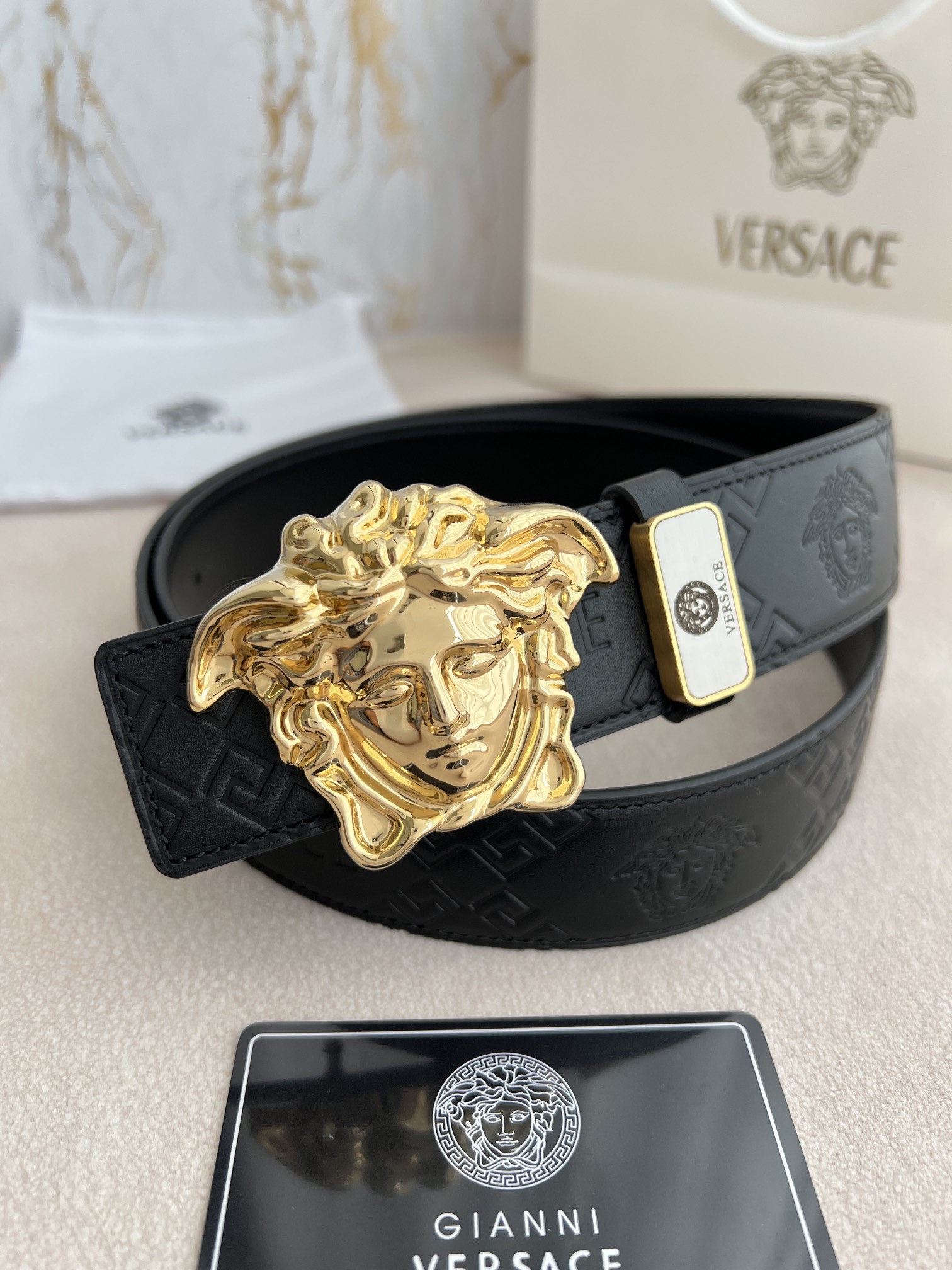 I0  VERSACE.范思哲原单腰带·皮带 型号：挂扣,经典人头纯铜材质扣头,图片实物拍摄 材料：百分百头层牛皮,保证真皮.24k纯铜扣双面可用专柜同等质量, 双面头层牛皮经典人头印花头层平纹皮底,经典人头纯铜材质扣头,双面可用,送人自用首选 包装请认准如图专柜包装,赠送打孔器,原版电子发票,宽度3.8mm