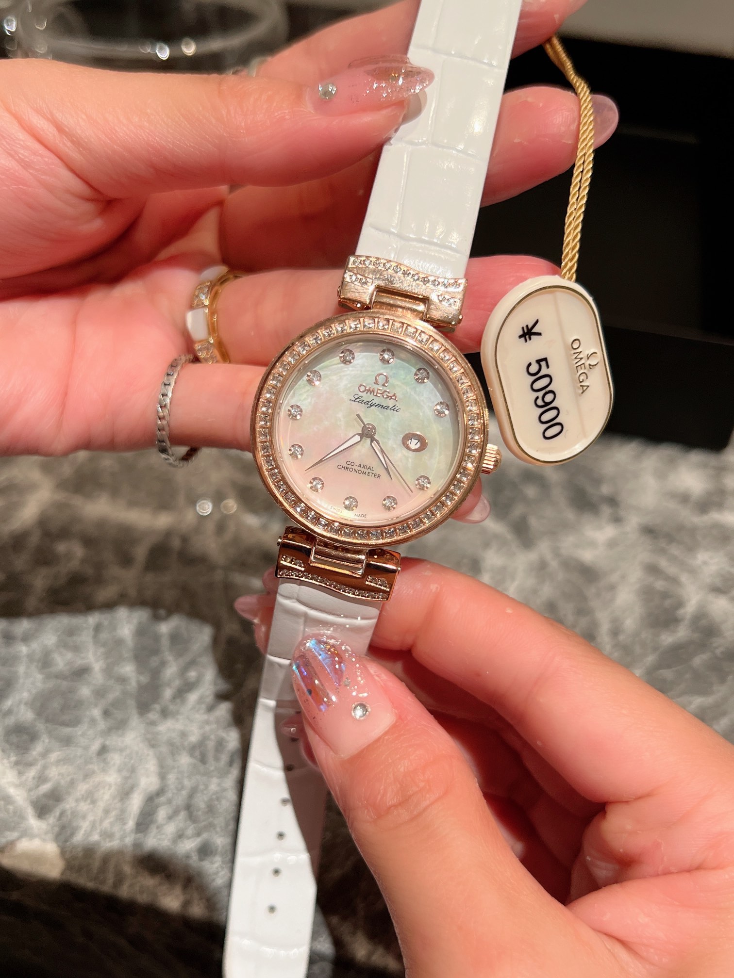 💰390全新欧米茄蝶飞系列腕表#表壳由精钢和施华洛世奇真钻制成，表盘采用垂直拉丝工艺，表圈使用2*2方石施华洛世奇钻，表壳侧边点缀颗颗闪烁的真钻施华洛钻石，呈现出迷人的太阳射线打磨效果，在璀璨钻石时标的点缀下，更显格调。珍珠贝表面与小牛皮表带完美搭配