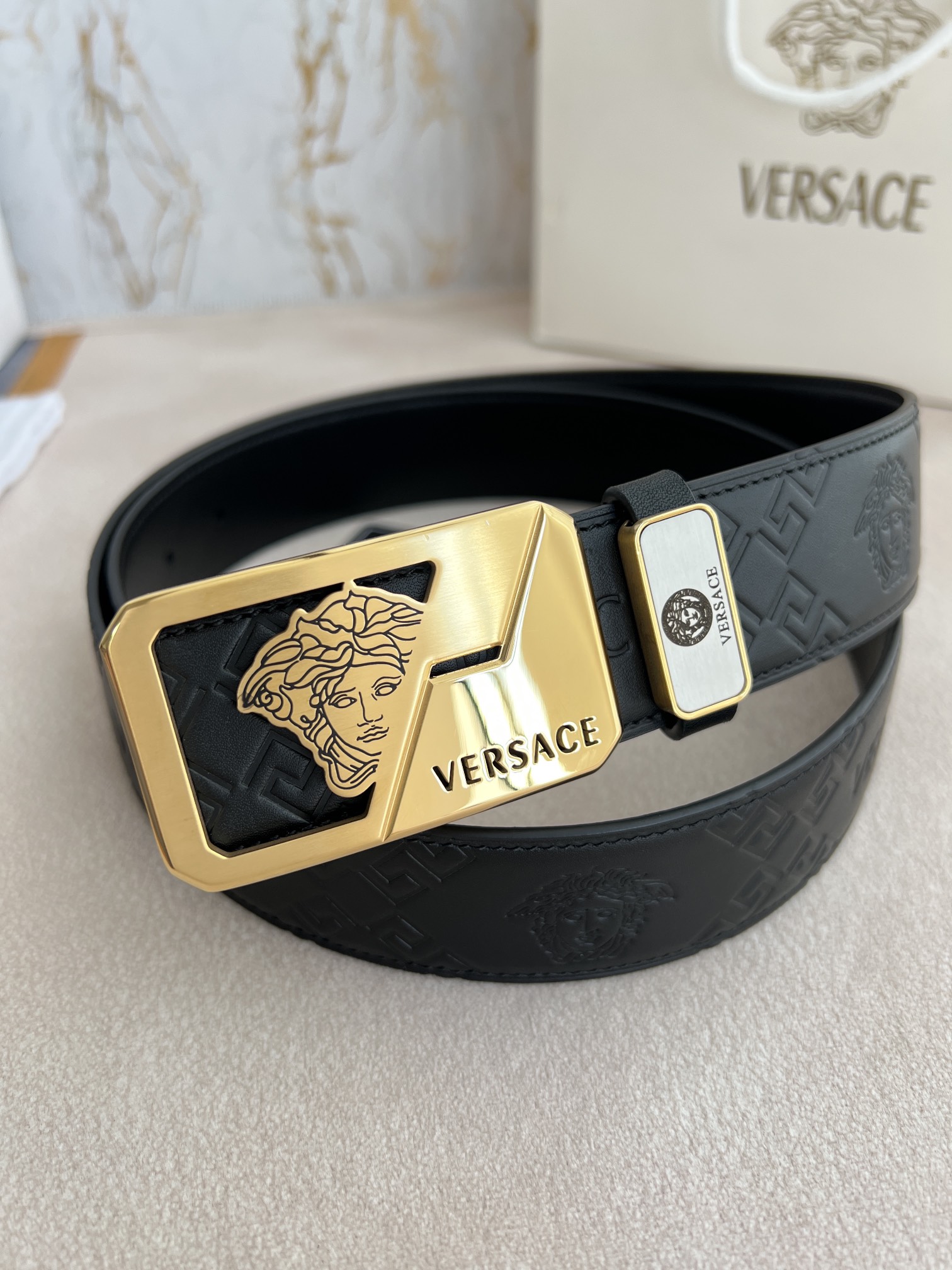 I5  VERSACE.范思哲原单腰带·皮带 型号：挂扣,经典人头纯钢材质扣头,头层牛皮,图片实物拍摄 材料：百分百头层牛皮,保证真皮.24k纯铜扣双面可用专柜同等质量, 双面头层牛皮经典人头印花黑头层牛皮平纹底,金扣,经典人头纯钢材质扣头,双面可用,可自由裁剪,送人自用首选 包装请认准如图专柜包装,赠送打孔器,原版电子发票,宽度3.8cm