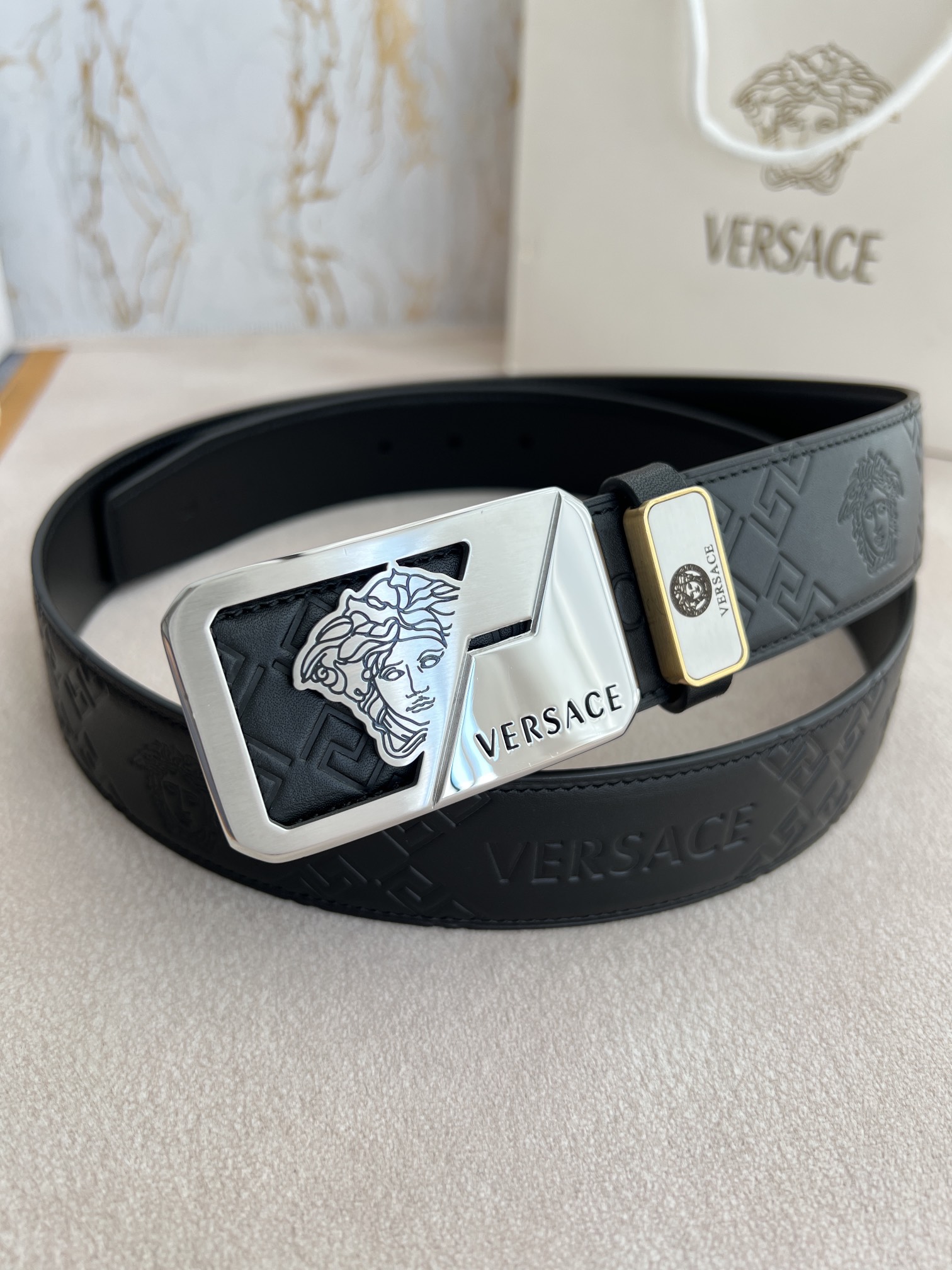 I5  VERSACE.范思哲原单腰带·皮带 型号：挂扣,经典人头纯钢材质扣头,头层牛皮,图片实物拍摄 材料：百分百头层牛皮,保证真皮.24k纯钢扣双面可用专柜同等质量, 双面头层牛皮经典人头印花黑头层牛皮平纹底,经典人头纯钢材质扣头,双面可用,可自由裁剪,送人自用首选 包装请认准如图专柜包装,赠送打孔器,原版电子发票,宽度3.8cm