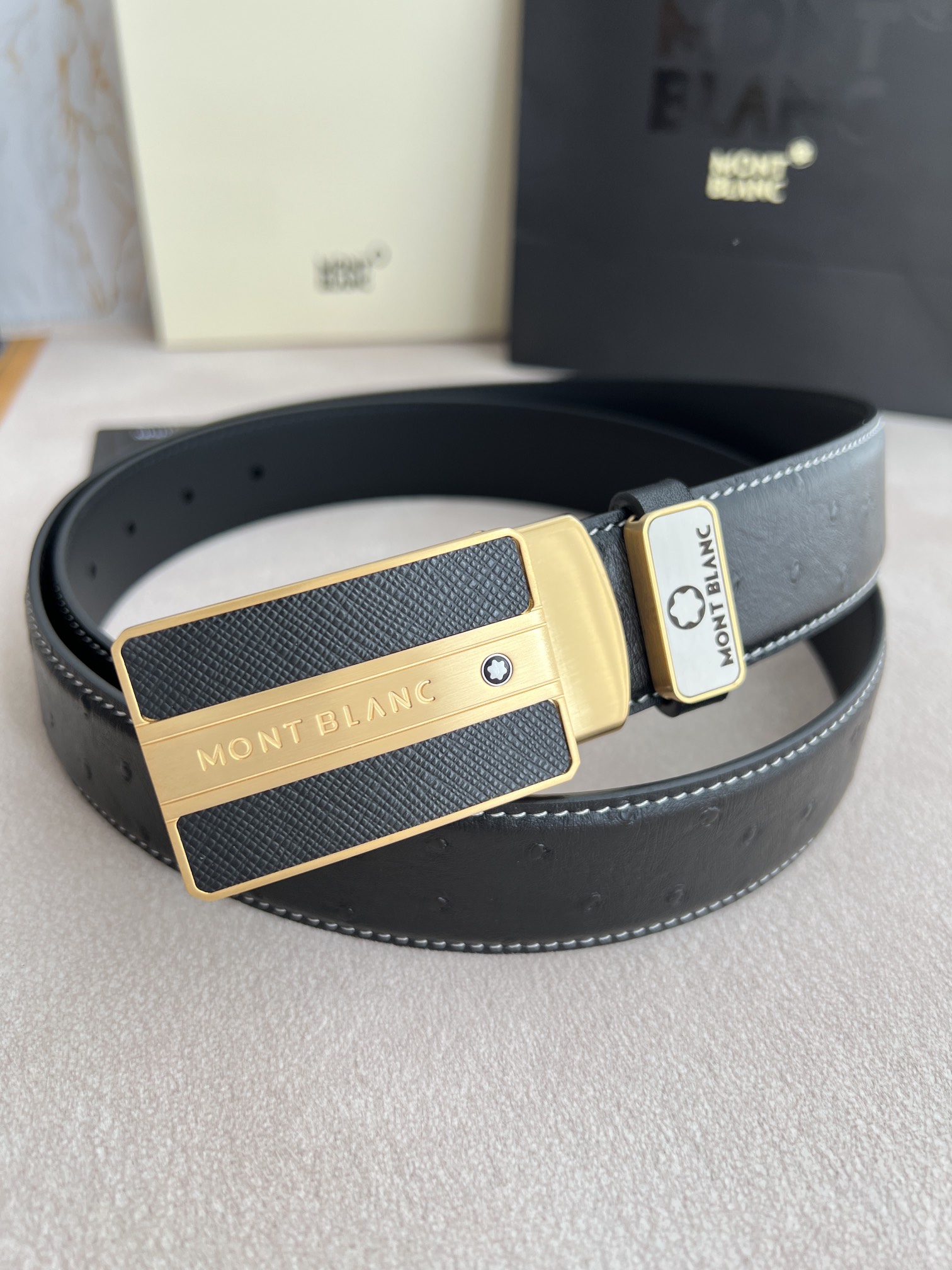 I0  Montblanc 万宝龙   Montblanc原单·腰带·皮带 型号：挂扣,原版经典精品贴皮挂扣,实物拍摄,原版头层牛皮 材料：百分百头层牛皮,保证真皮.双面可用专柜同等质量,原版头层牛皮鸵鸟纹白线头层牛皮平纹底,金扣,纯钢材质贴皮挂扣,可双面使用,可自由裁剪,送人自用首选 包装请认准如图专柜包装,赠送打孔器,原版电子票,宽度3.5cm