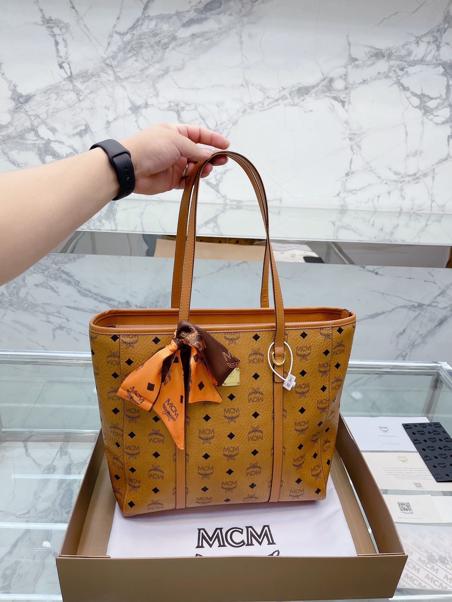 K0 原单 牛皮 “复刻 牛皮版本” 全套礼盒包装 mcm新品手提袋，真是方便又实用哦运用精巧技艺所打造的经典 Visetos涂层帆布配件单品经久耐用，它的耐用度就如同其传奇之名我们经典的Visetos字母组合印花的涂层帆布成就了这款曲线利落的手提袋。耐用且具有标志性，它的可拆卸及可调节式人造革/牛皮革链条斜挎包肩带能随心所欲地实现任何您想要的造型。尺寸：32 32cm