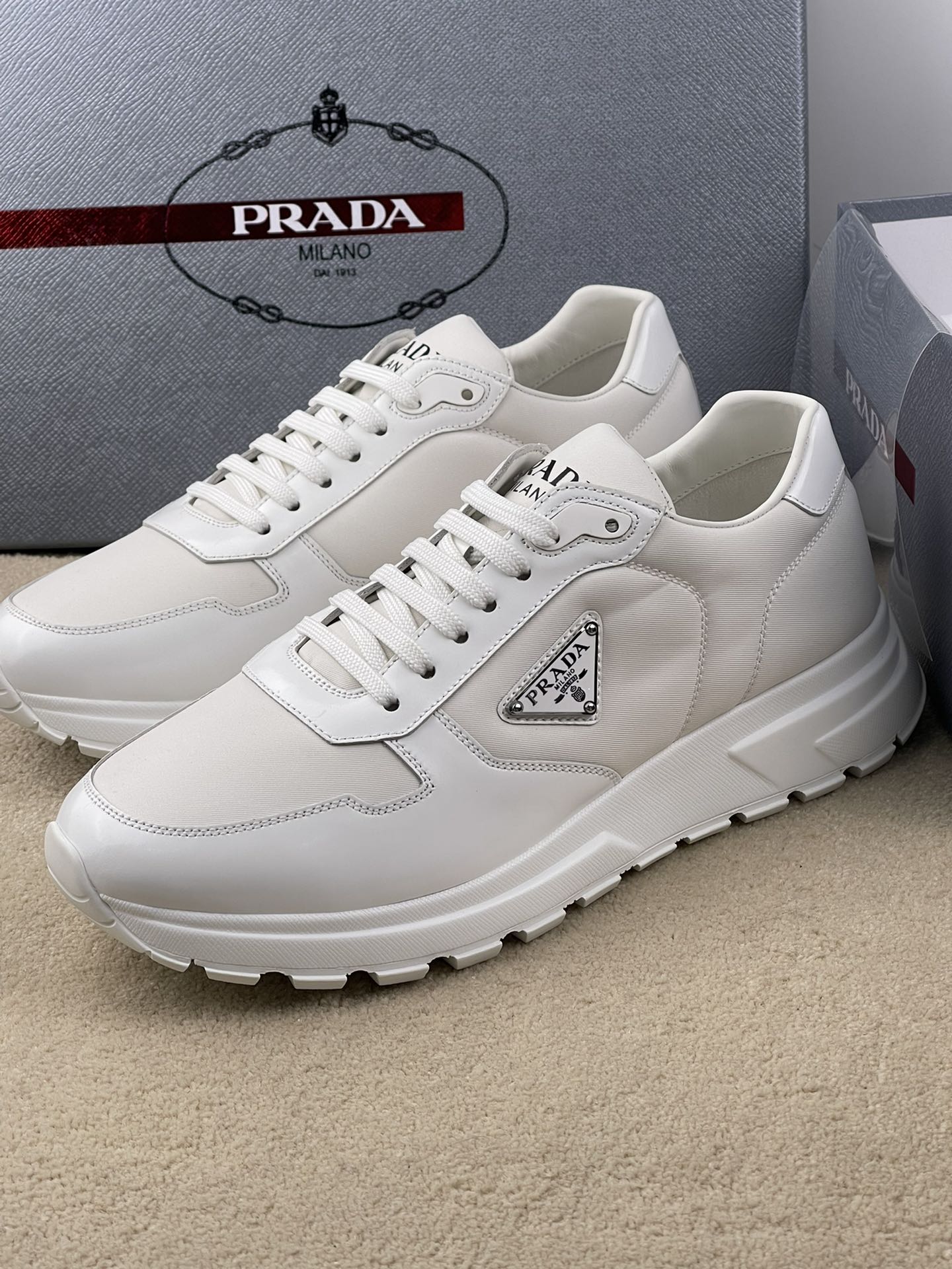 NO:271068,The latest update of Prada PRAX 01 sports shoes combine elegant creative design and typical materials from the Prada series. The shoe body is made of innovative Re-Nylon recycled nylon and glossy leather made of marine plastic recycling. A triangle logo with a novel sporty style embellishes the sides, highlighting the brand's characteristics. The tread pattern rubber sole gives the silhouette a mix of charm. Details Product number: 2EE369_3LF5_F0632_F_G laces Enamel triangle logo on the upper tongue Prada Milano screen printed logo on the screen Lightweight rubber sole with serrated edges 4.5 cm thick sole removable leather-covered insole Normal size 39 40 41 42 43 44 size,,prada,sneakers19860909Prada最新款更新 PRAX 01 运动鞋融优雅的创意设计以及Prada系列典型的材质于一身.鞋身采用海洋塑料回收物所制的创新性Re-Nylon再生尼龙和亮面皮革打造.蕴含新颖运动格调的三角形徽标点缀侧面,彰显品牌特色.胎面花纹橡胶厚底赋予廓形混搭魅力. 细节 商品货号: 2EE369_3LF5_F0632_F_G 鞋带 鞋面珐琅三角形徽标 鞋舌Prada Milano丝网印刷徽标 轻质橡胶鞋底,配锯齿状沿条 鞋底厚4.5厘米 可拆卸皮革包覆内底 正常码39 40 41 42 43 44码,,prada,sneakers,Men's shoes