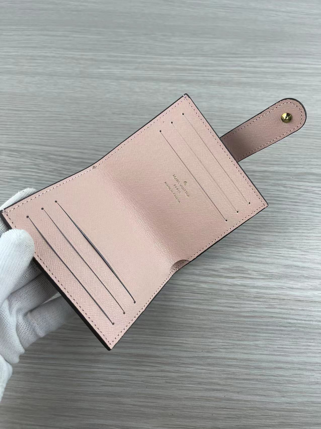 Pink leather card holder with cards inside