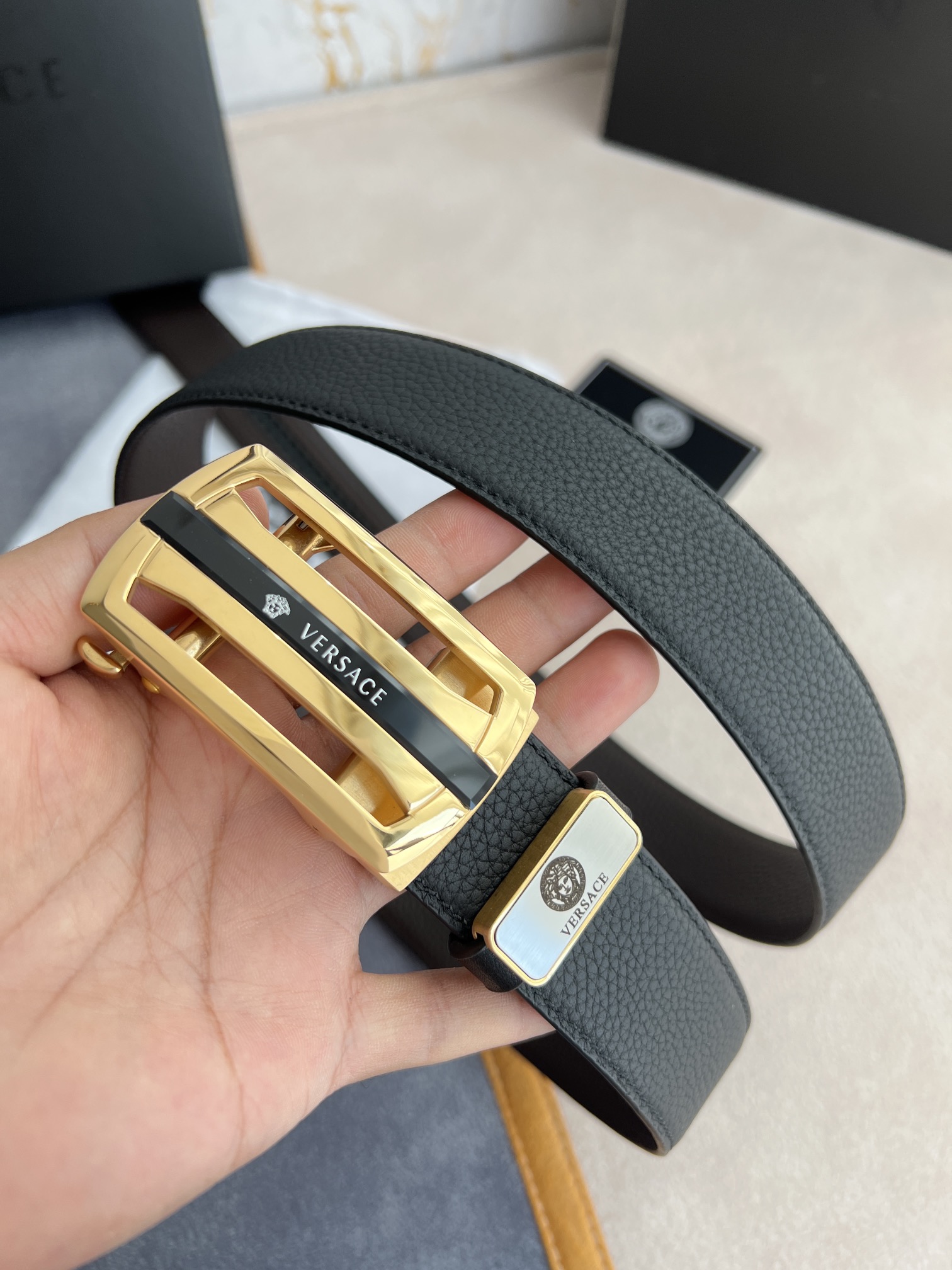 I5  Versace 范思哲 VERSACE.皮带腰带自动皮带p 型号：自动带身,纯钢材质经典人头自动扣,图片实物拍摄 腰带：百分百头层牛皮,自动带身,保证真皮.24k纯钢扣永不掉色专柜同等质量,经典头层牛皮双面荔枝纹,黑咖,金扣,镂空人头纯钢材质扣头,可自由裁剪,送人自用首选 包装请认准如图专柜包装,赠送拆卸工具,原版电子票,宽度3.5cm