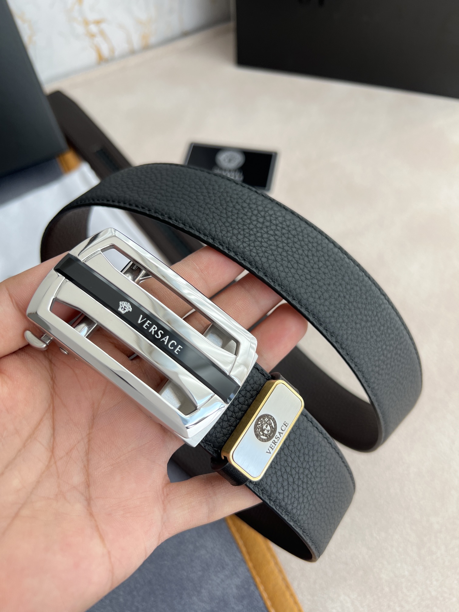 I5  Versace 范思哲 VERSACE.皮带腰带自动皮带p 型号：自动带身,纯钢材质经典人头自动扣,图片实物拍摄 腰带：百分百头层牛皮,自动带身,保证真皮.24k纯钢扣永不掉色专柜同等质量,经典头层牛皮双面荔枝纹,黑咖,镂空人头纯钢材质扣头,可自由裁剪,送人自用首选 包装请认准如图专柜包装,赠送拆卸工具,原版电子票,宽度3.5cm