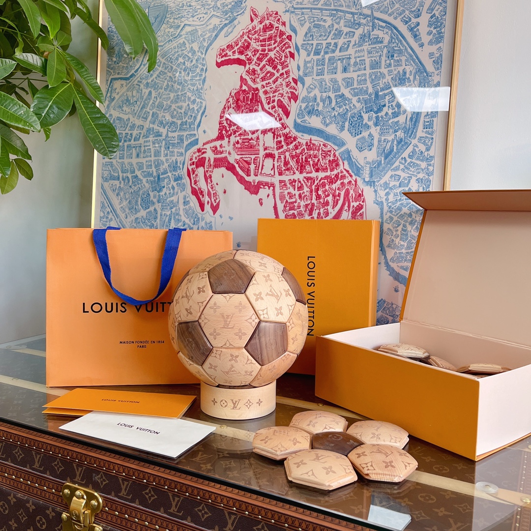 本款木质足球纪念路易威登与FIFA World Cup Qatar 2022的联名合作。Monogram图案镌刻搭配北美黑胡桃及克罗地亚榉木两种材质，随时间流逝呈现别致色泽，成就收藏甄选，随附圆形克罗地亚榉木底座呈现完美视觉效果。路易威登一直以来以形形色色的运动产品陪伴着运动员们，该品牌将精湛工艺与创意精神相结合，打造出此款木质足球摆件。该摆件需自行安装完成，配有10个A型号六边形木块，10个B型号六边形木块，12个C型号五边形木块。详细特征球尺寸：Φ 22cm(直径)底座尺