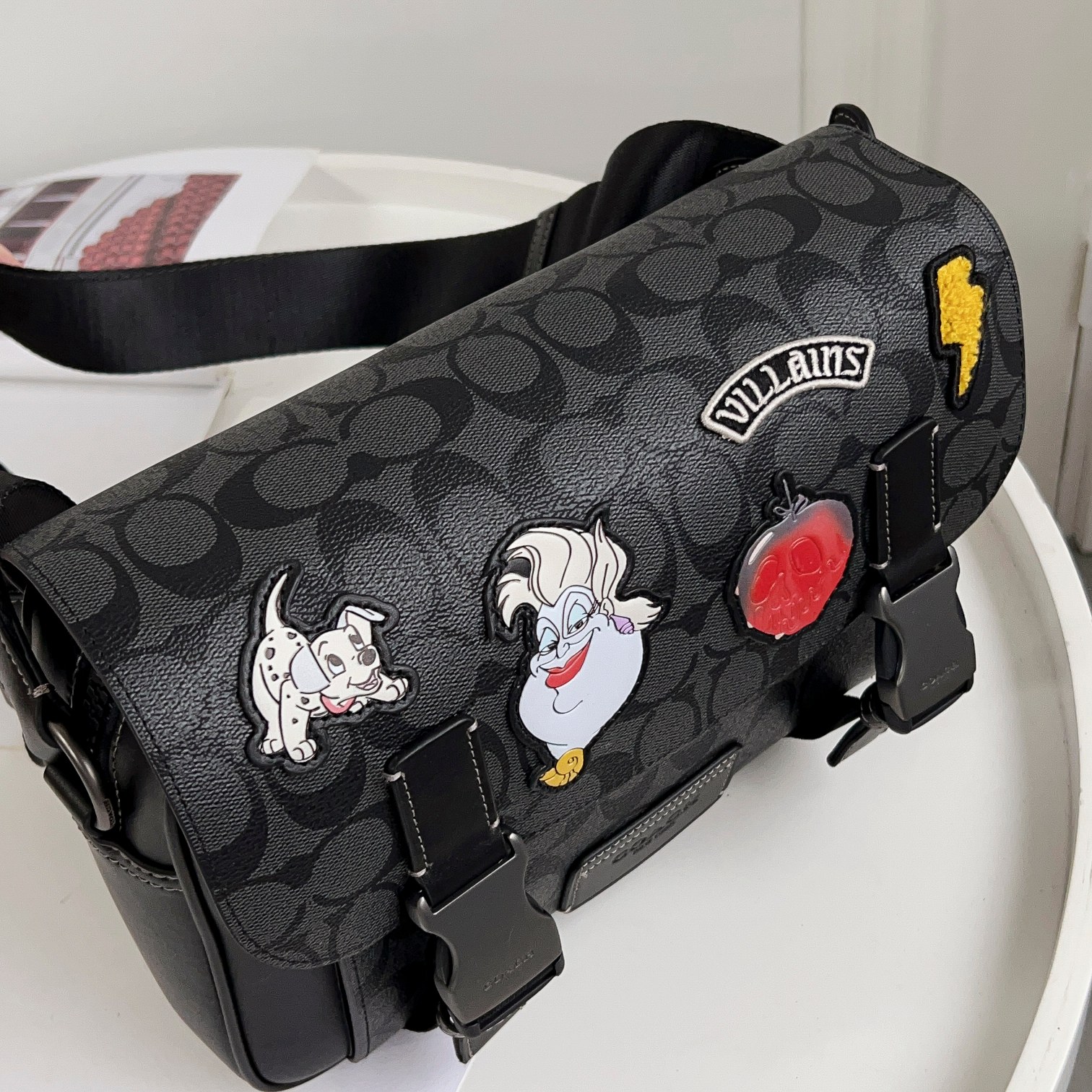 Coach CC037男包 标志贴饰DISNEY TRACK斜挎包最新款邮差包最 的百搭色 非常适合潮男外搭 有种邻家哥哥的感觉 翻盖的设计加上卡扣两端非常 打开后 里面是一个隔层 隔层是吸铁式的放手机拿取比较方便 还有一个拉链隔层 空间非常大 包容性非常大 后面还有一个隔层 的pvc logo材质 耐用耐磨