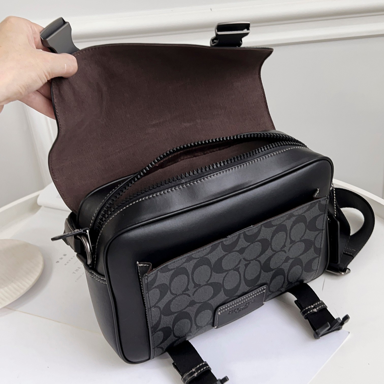 Coach CC037男包 标志贴饰DISNEY TRACK斜挎包最新款邮差包最 的百搭色 非常适合潮男外搭 有种邻家哥哥的感觉 翻盖的设计加上卡扣两端非常 打开后 里面是一个隔层 隔层是吸铁式的放手机拿取比较方便 还有一个拉链隔层 空间非常大 包容性非常大 后面还有一个隔层 的pvc logo材质 耐用耐磨
