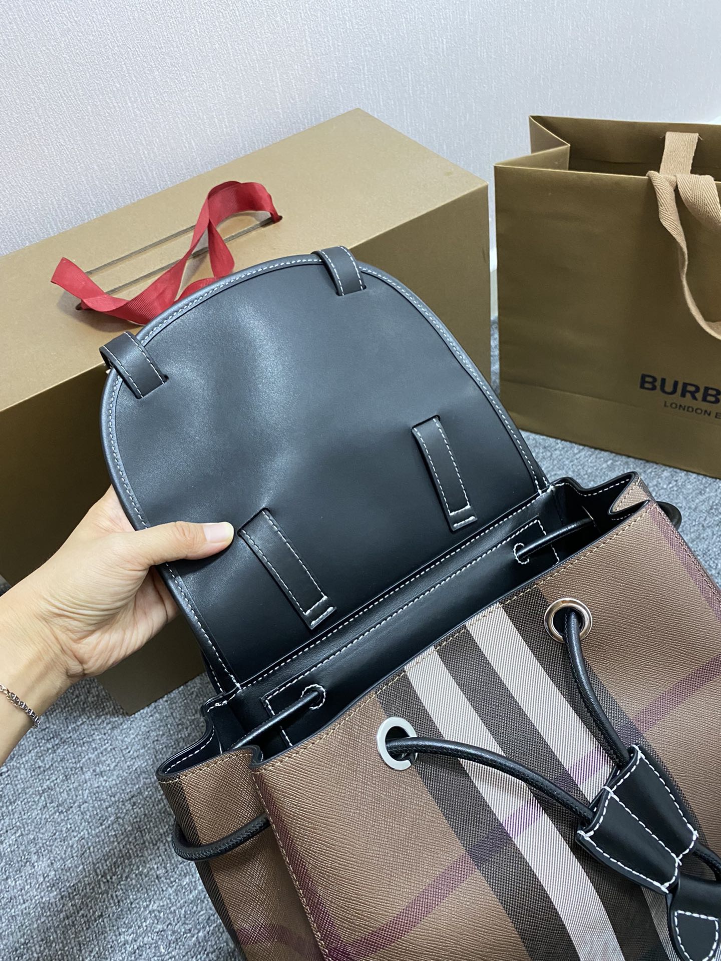 B家桦木棕格双肩包🎒焕新选用格纹环保帆布制作。该环保帆布材质主要运用可再生资源制造，相较于传统的涂层帆布，时髼百搭，男女通用，上班族学生都可，容量超级大能装笔记本电脑，尺寸：36/25/15