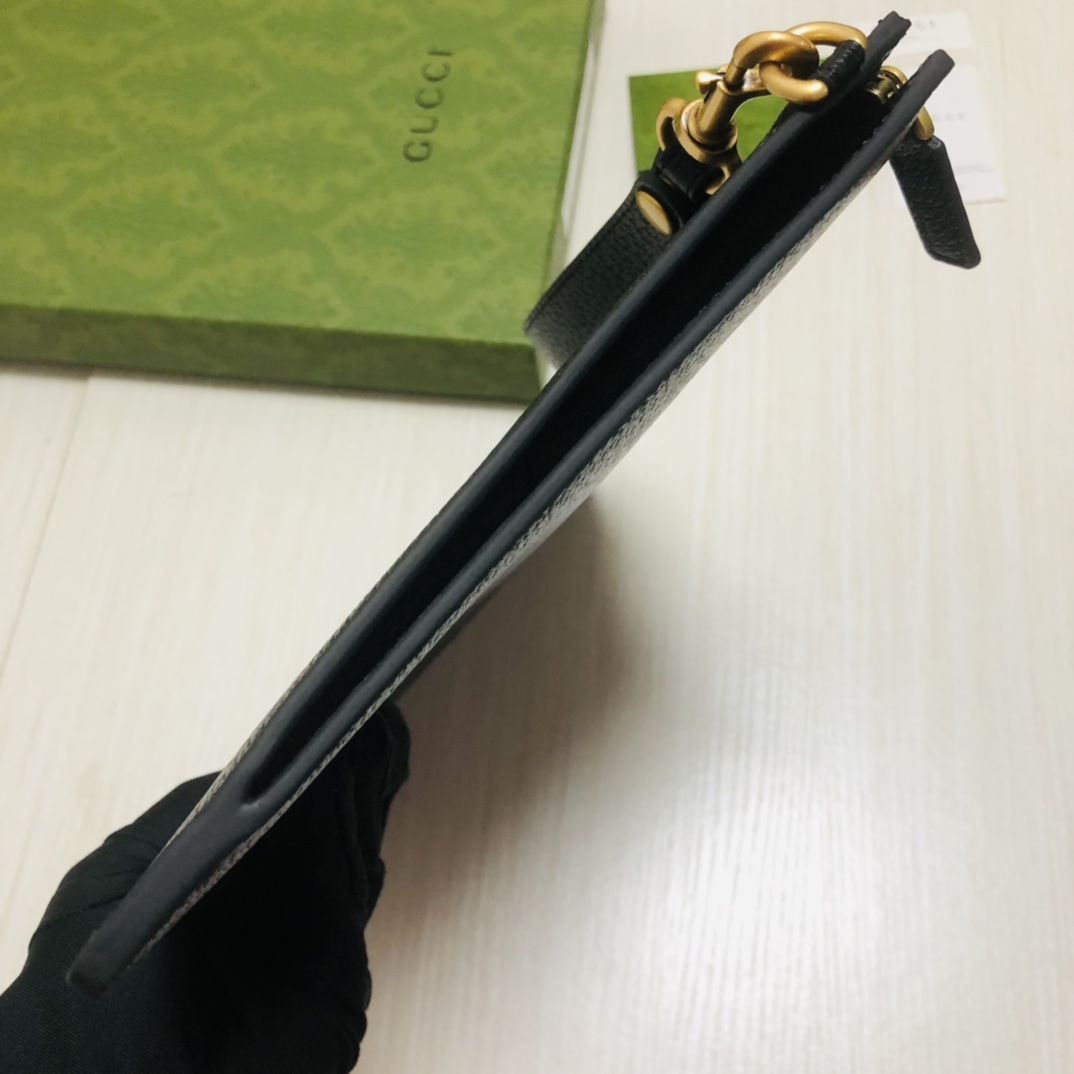 此款纤薄手拿包，GG金属配件醒目独特。采用热压小牛皮制作，以获得野猪猪皮效果，打造织纹外观。款号。尺寸：