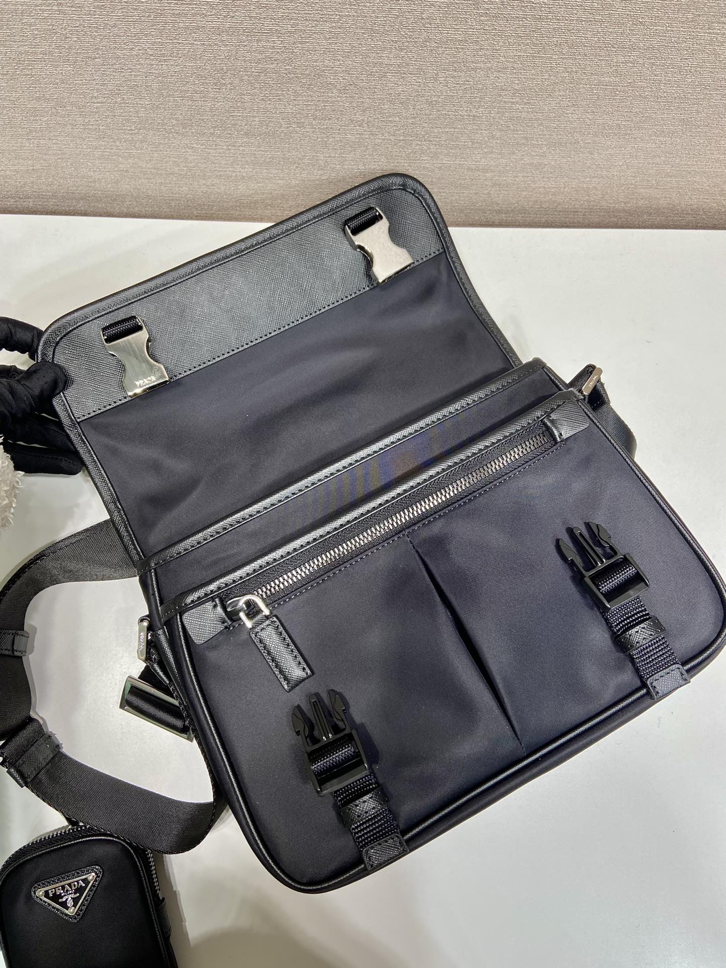 🎉邮差包🎉2VD769中号🎉原单货👍👍这款尼龙翻盖手袋饰有经典的Saffiano皮革饰边，配有两枚旁开扣