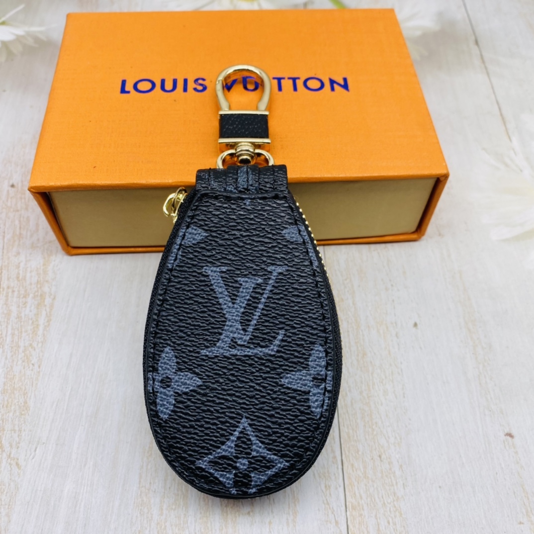 A hand holding the leather car keychain
