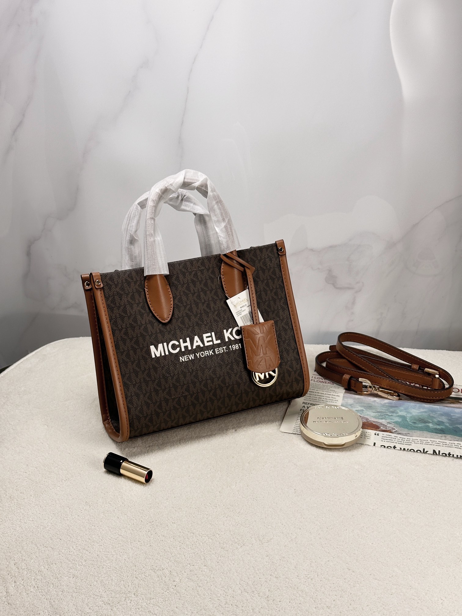 Michael Kors 印花打造包身，上缀 Michael Kors 字母印花装饰，皮革