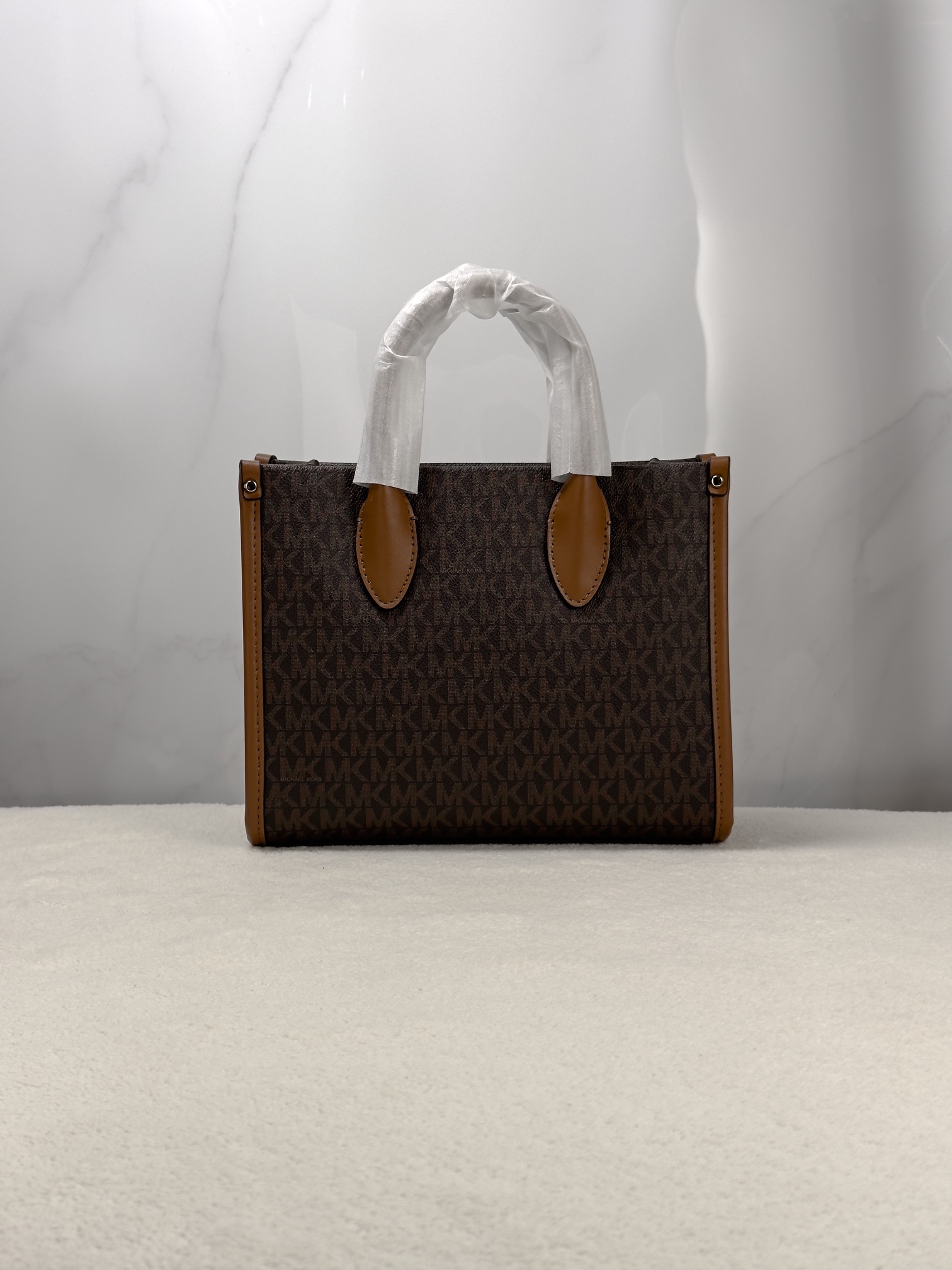 Michael Kors 印花打造包身，上缀 Michael Kors 字母印花装饰，皮革