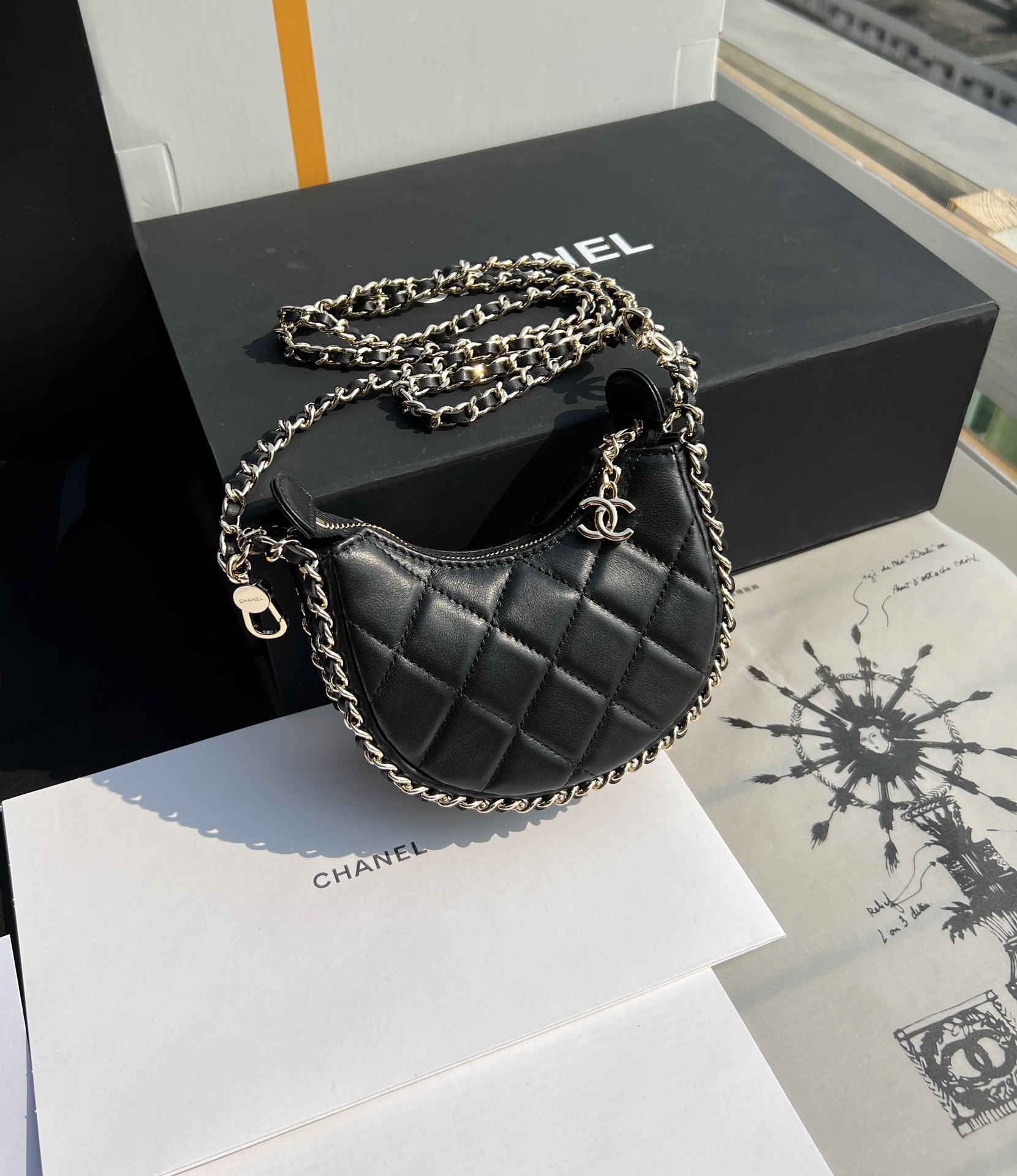 Черная сумка-полумесяц с золотой фурнитурой Chanel