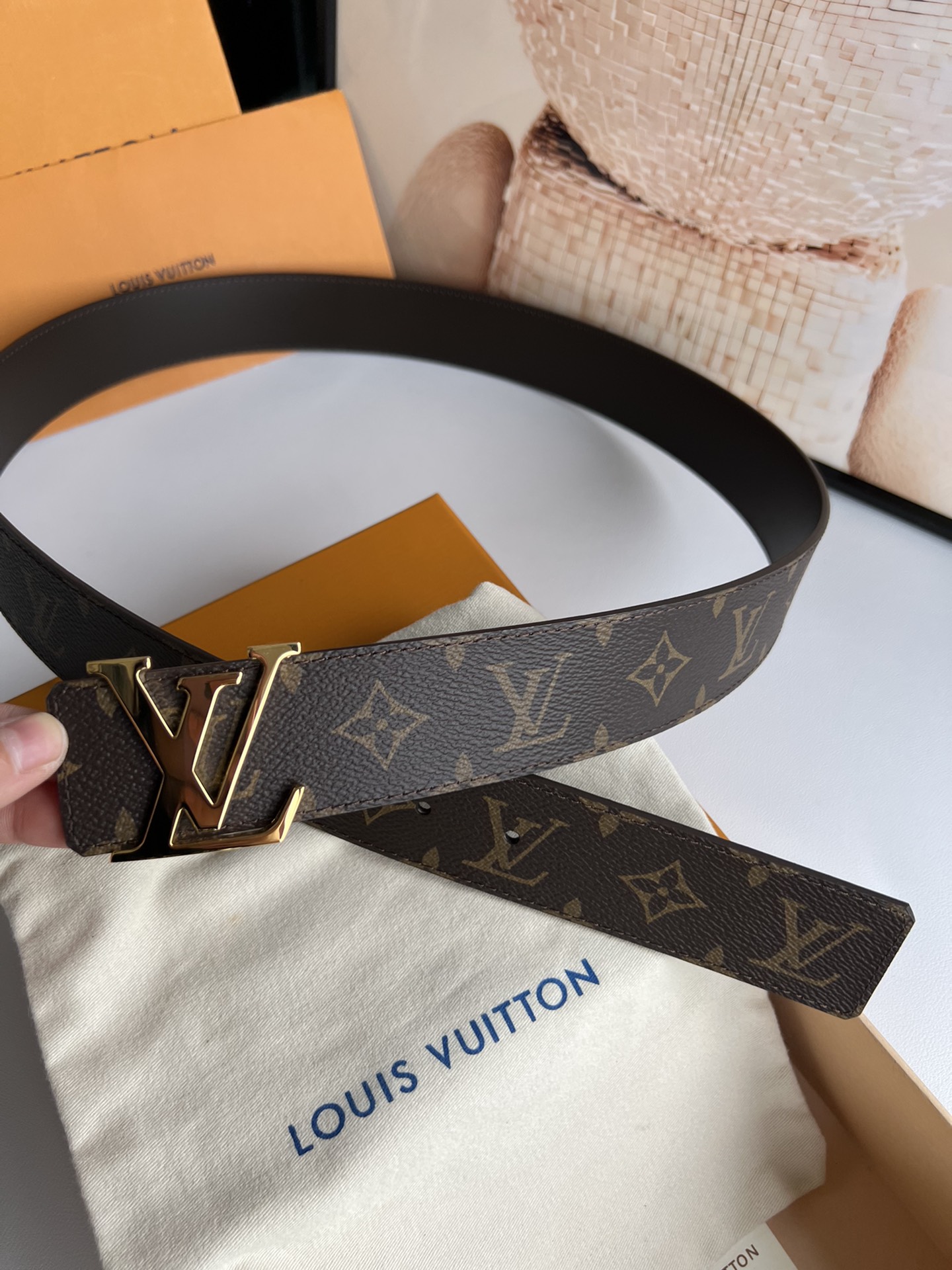 LV Initiales 双面腰带拼合经典Monogram帆布和素色皮革，搭配中央字母凹凸搭扣，提供多样