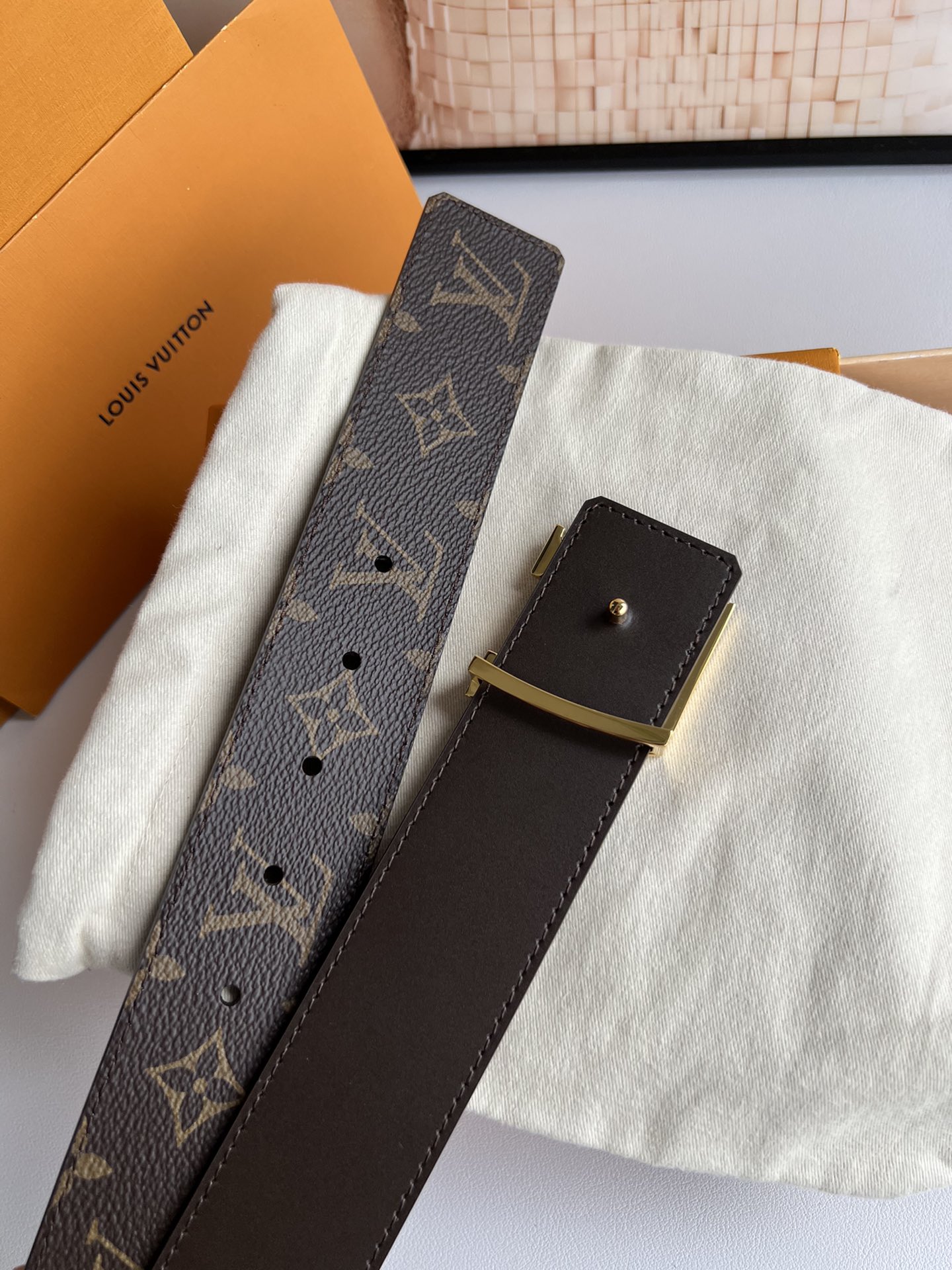 LV Initiales 双面腰带拼合经典Monogram帆布和素色皮革，搭配中央字母凹凸搭扣，提供多样