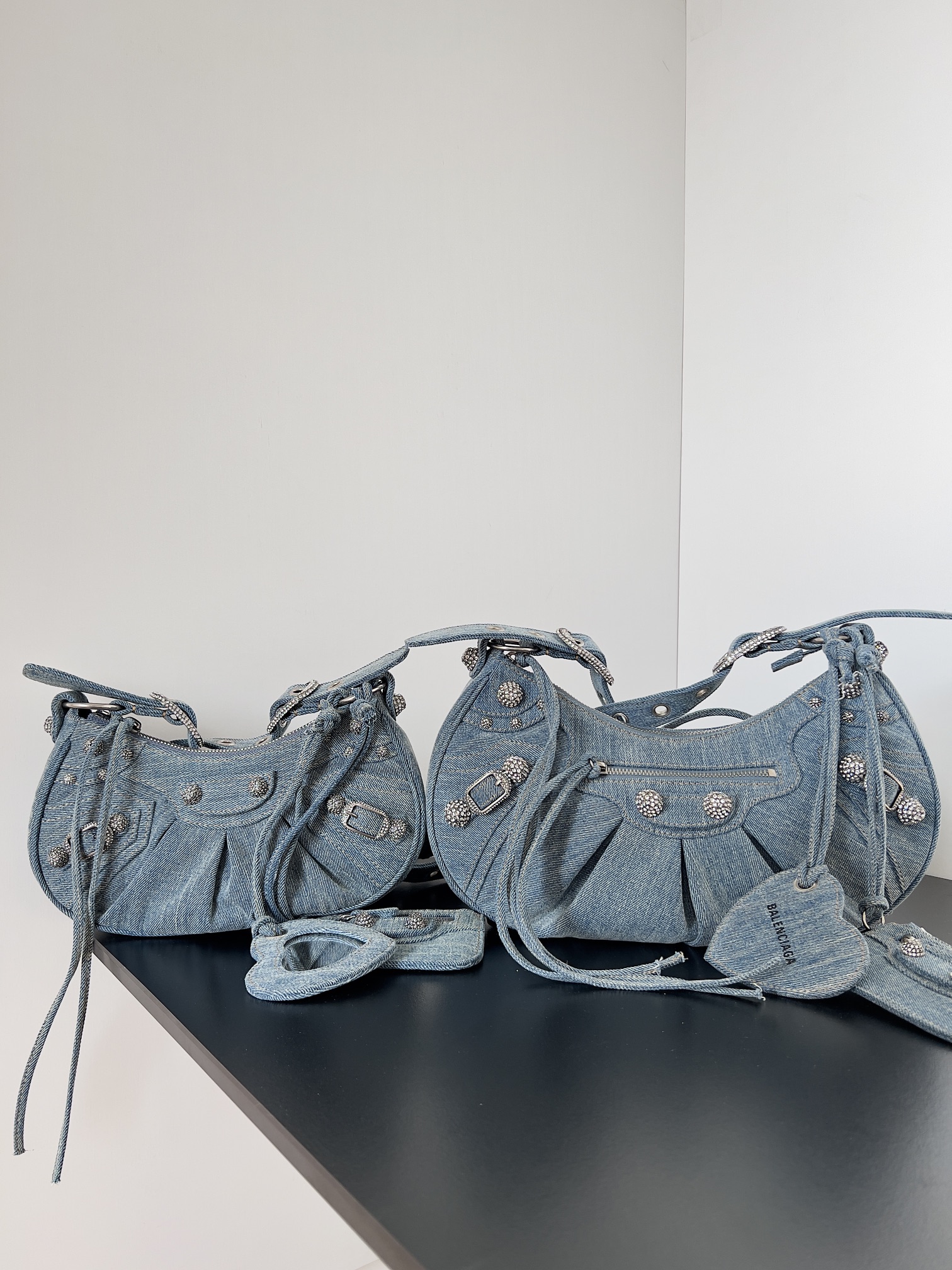 Denim blue Balenciaga Le Cagole series handbags combine their classic motorcycle rivet elements with the popular armpit bag