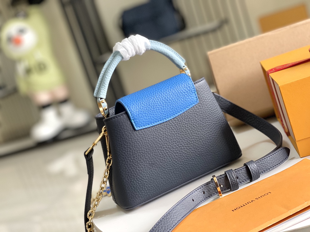 本款 Capucines 迷你手袋展现柔婉之美:Taurillon 皮革包身搭配浅色翻盖和顶部手柄,珐琅 Monogram 4
