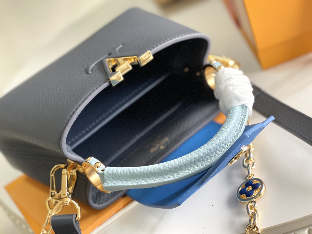 本款 Capucines 迷你手袋展现柔婉之美:Taurillon 皮革包身搭配浅色翻盖和顶部手柄,珐琅 Monogram 8