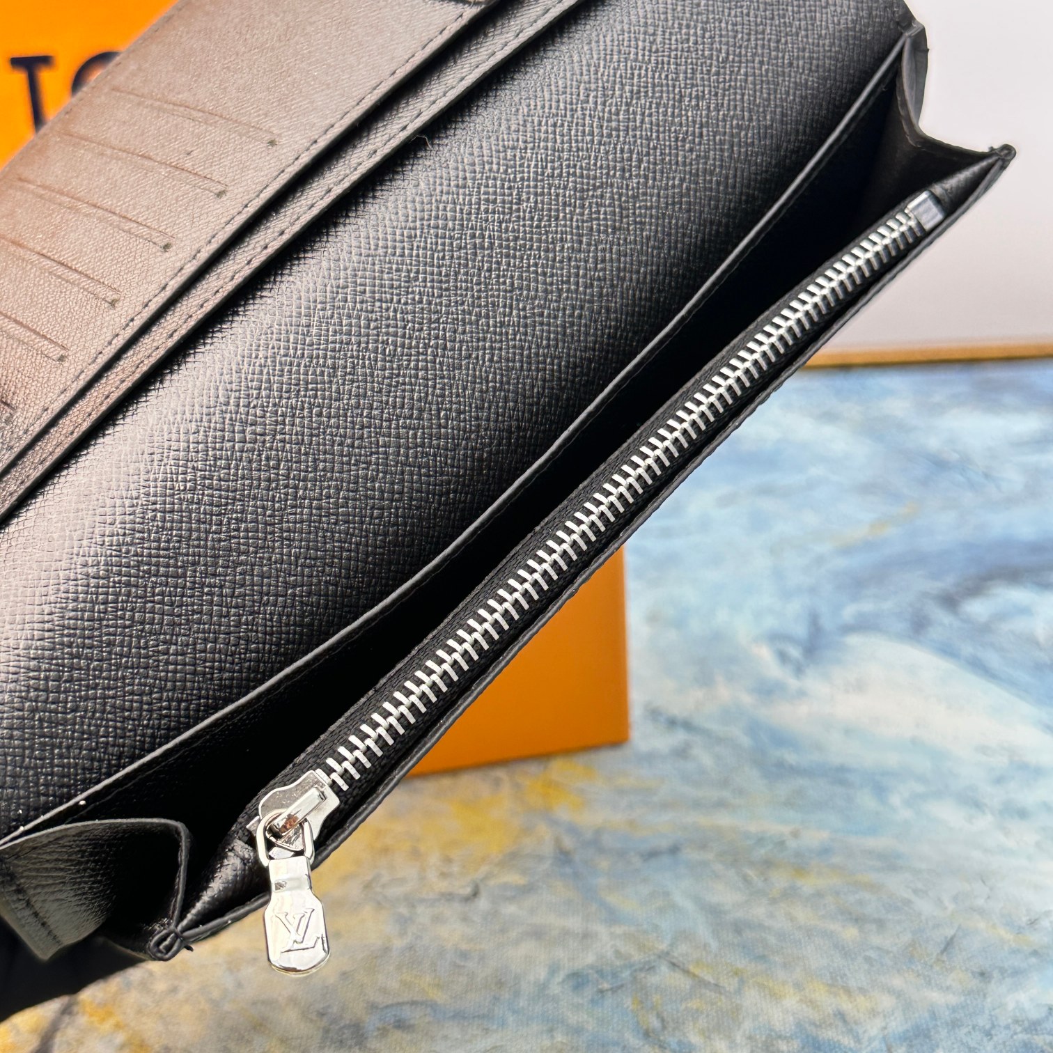 A hand holding the leather bifold wallet.