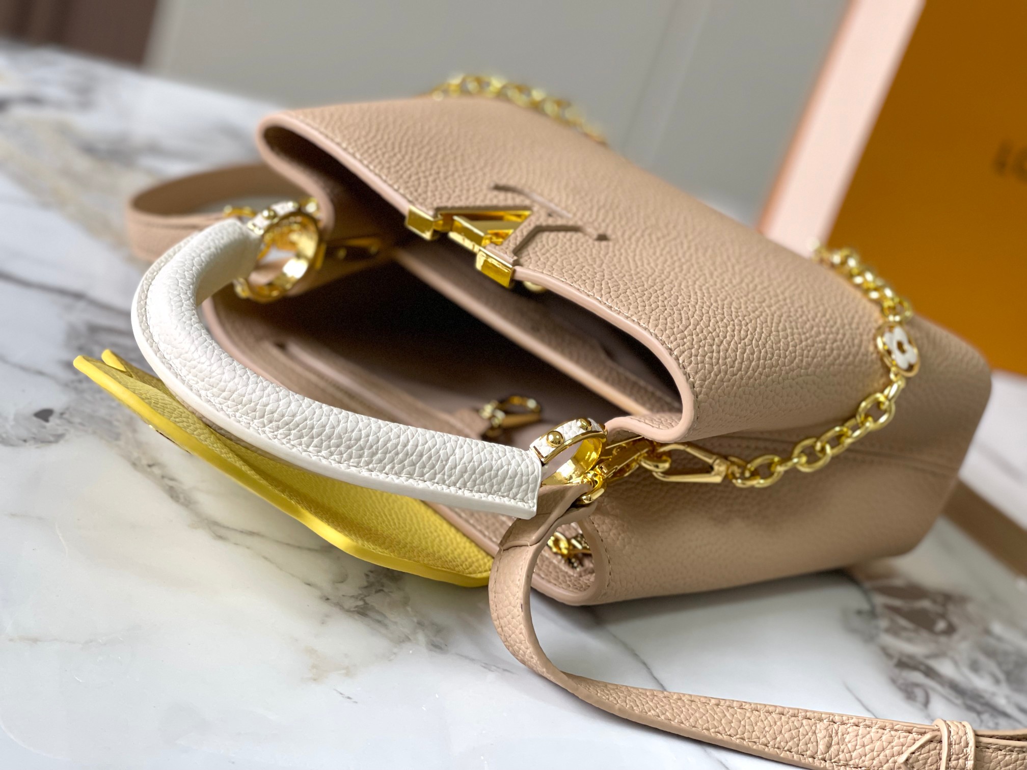 升级 M20844杏色花卉三拼
本款 Cap-ucines BB 手袋取材 Taurillon 皮革，隐