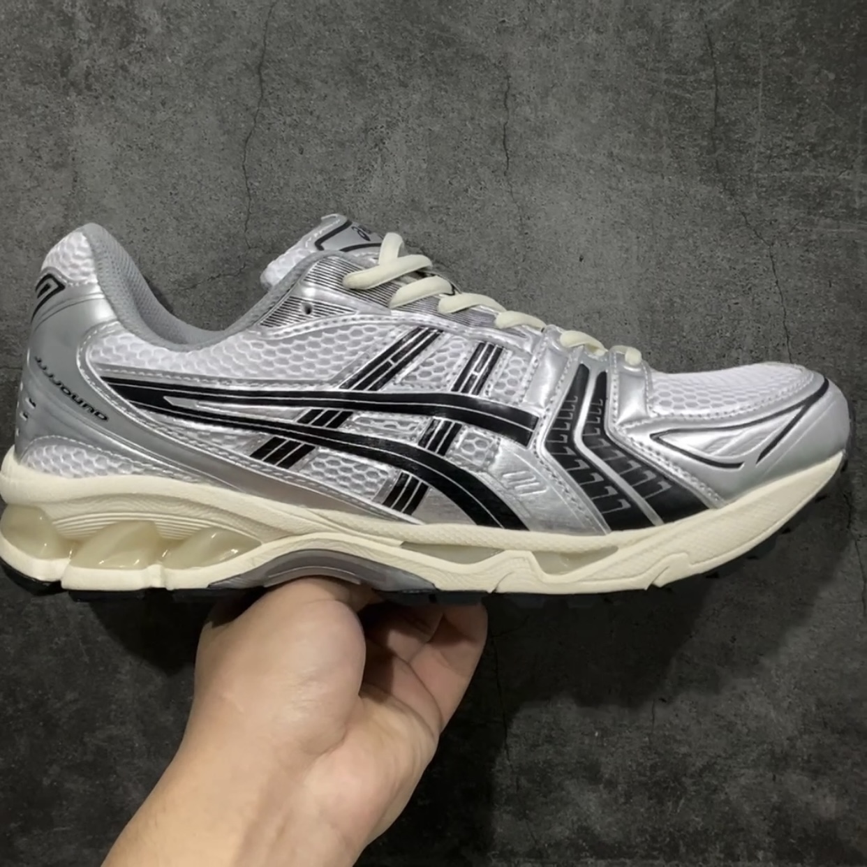 【纯原版】JJJJound x ASICS GEL-KAYANO 14 亚瑟士系列轻量缓震休闲运动跑步鞋n设计师 Hidenori Yamashita 以「Flash」一词为灵感，创造出未来感金属色鞋面，改造升级内在性能，由内而外全面革新，为 GEL-KAYANO 家族传承及经典跑鞋文化的延续，创下里程碑式作品。ASICS GEL – KAYANO 14 跑鞋重新诠释了复古的跑步形状，并以其 2000 年代后期的美学理念重新铺装，银色与蓝色的鞋面极为高档.网面铺陈与鞋面、鞋头多处细节位增添了透气性。ASICS GEL – KAYANO 14的鞋后跟部中底上以及多密度耐磨鞋底增加了 GEL 缓震胶，提供高抗冲击性、缓冲性、可保护脚部免受地面冲击的影响，穿着舒适性十足「入手同款」 尺码：35.5 36 37 37.5 38 39 39.5 40.5 41.5 42 42.5 43.5 44 45-莆田鞋批发中心